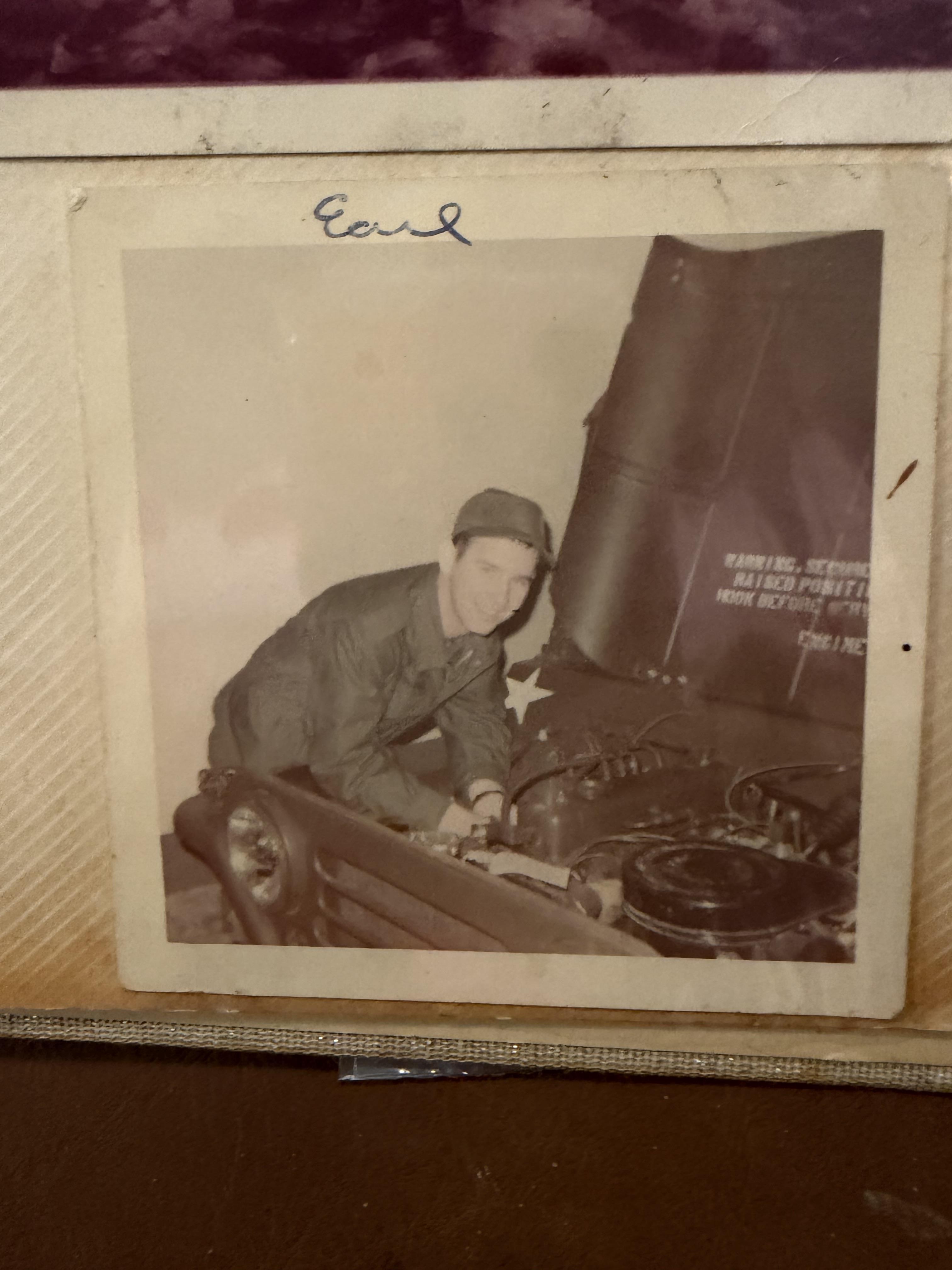 A man in uniform working on a car