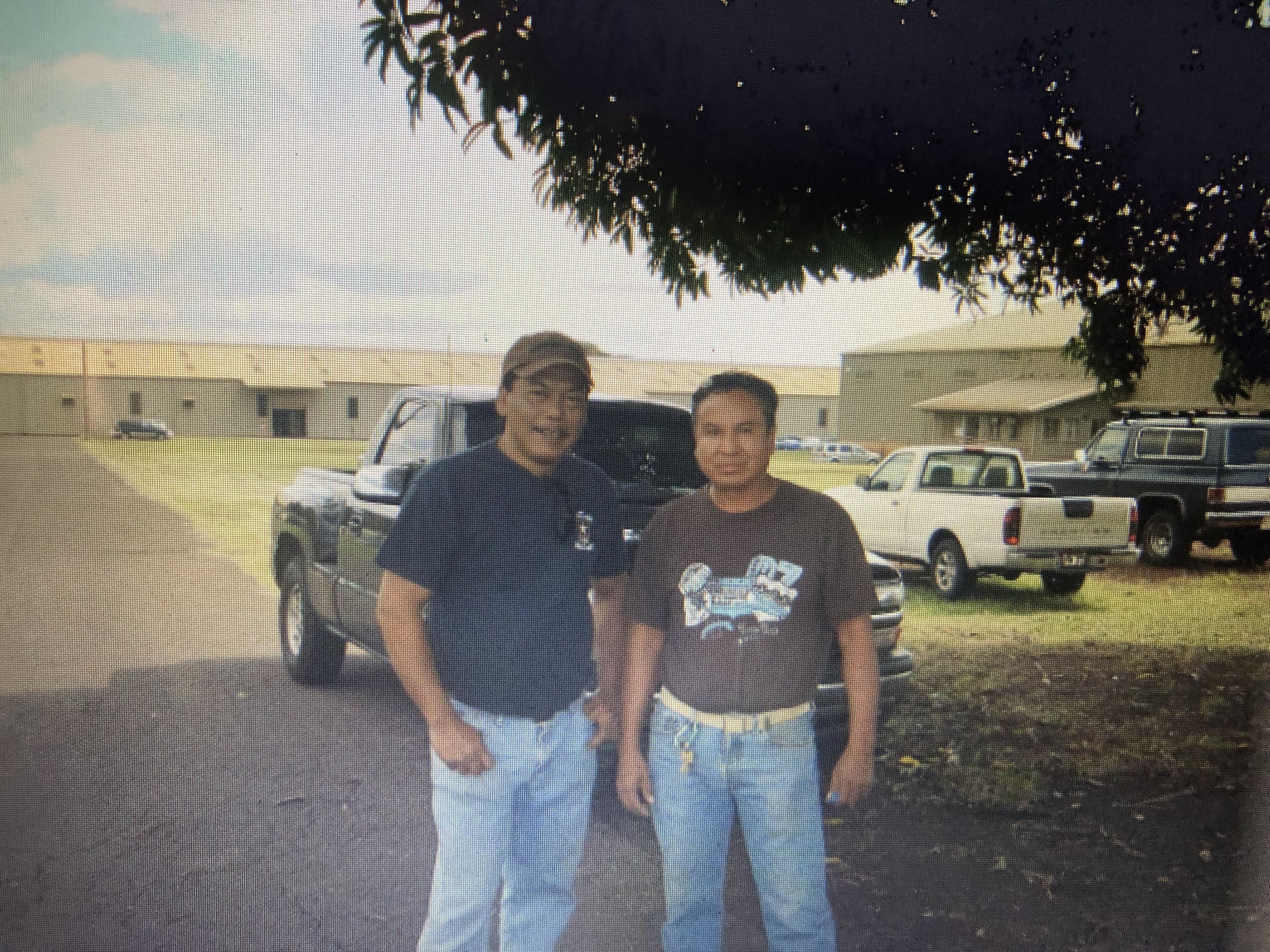 A couple of men standing in front of a truck
