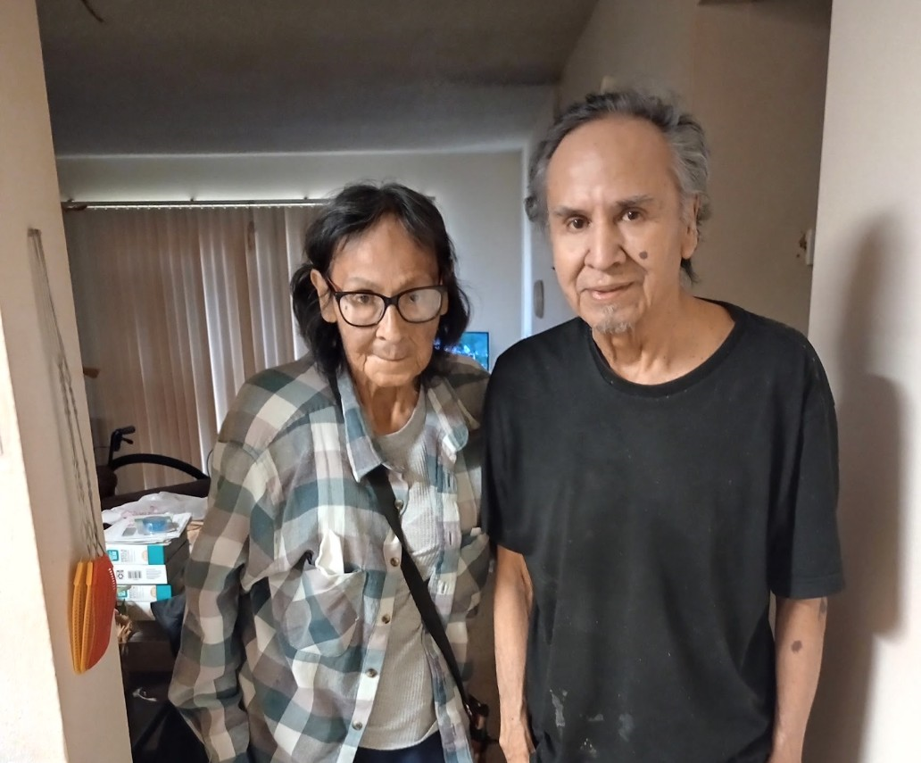 A man and woman standing in a hallway