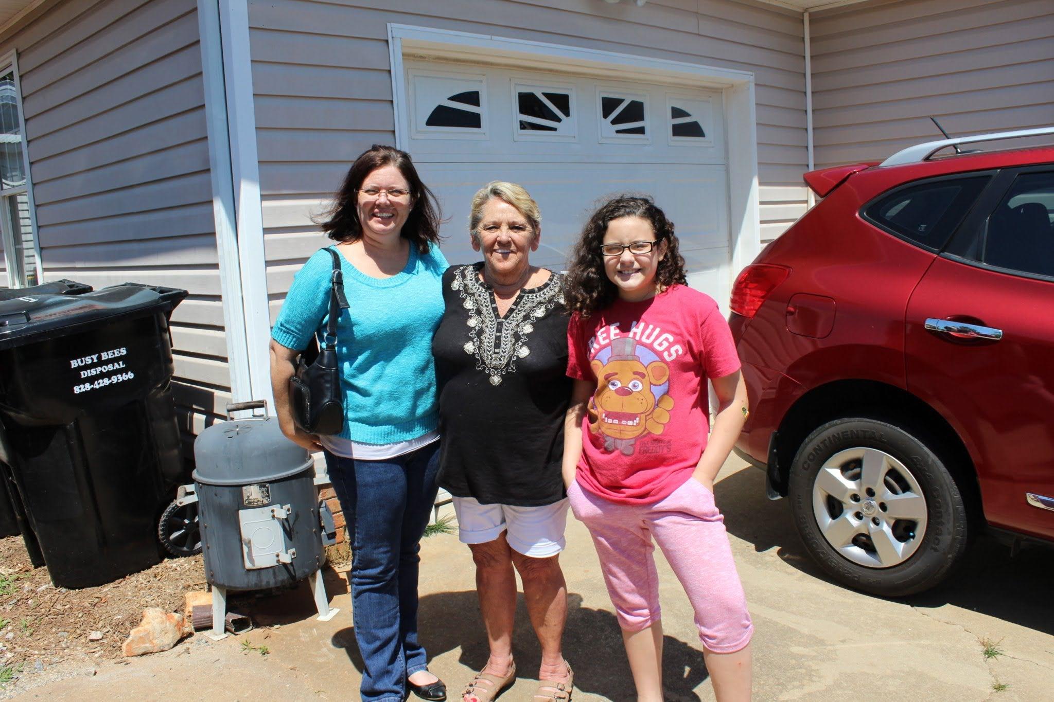 A group of women standing in front of a house