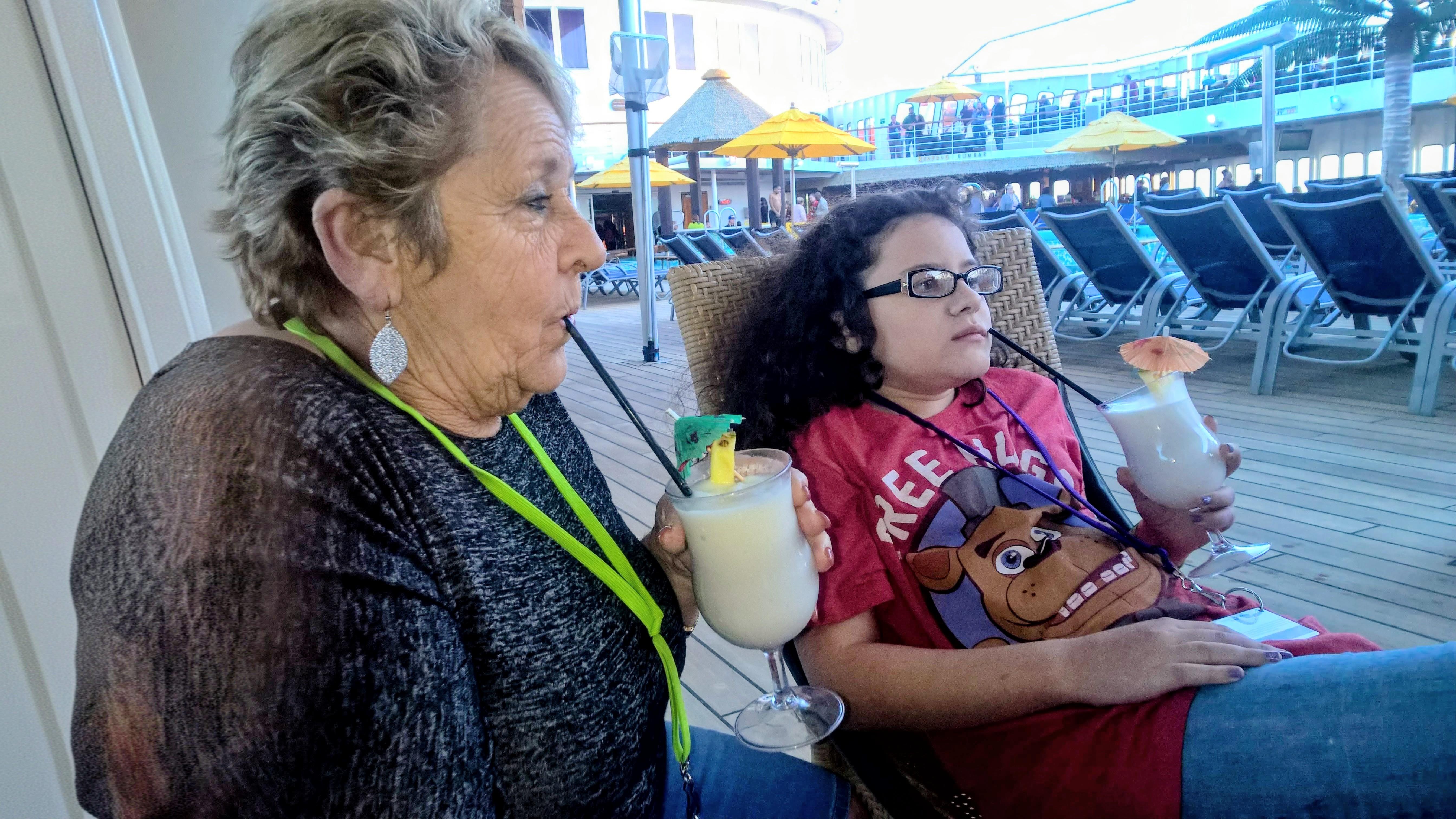 A woman and a girl drinking from a drink