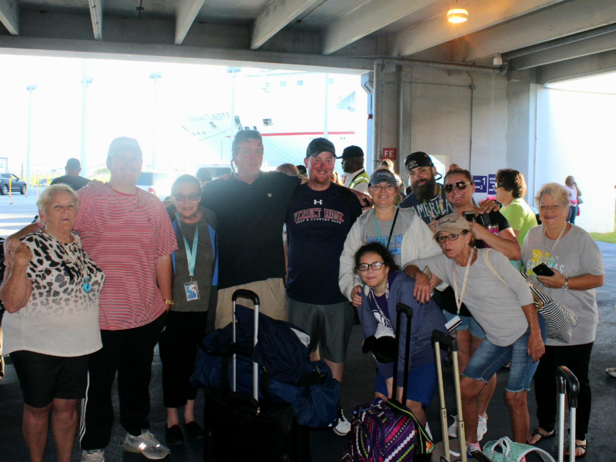 A group of people standing in a room with luggage