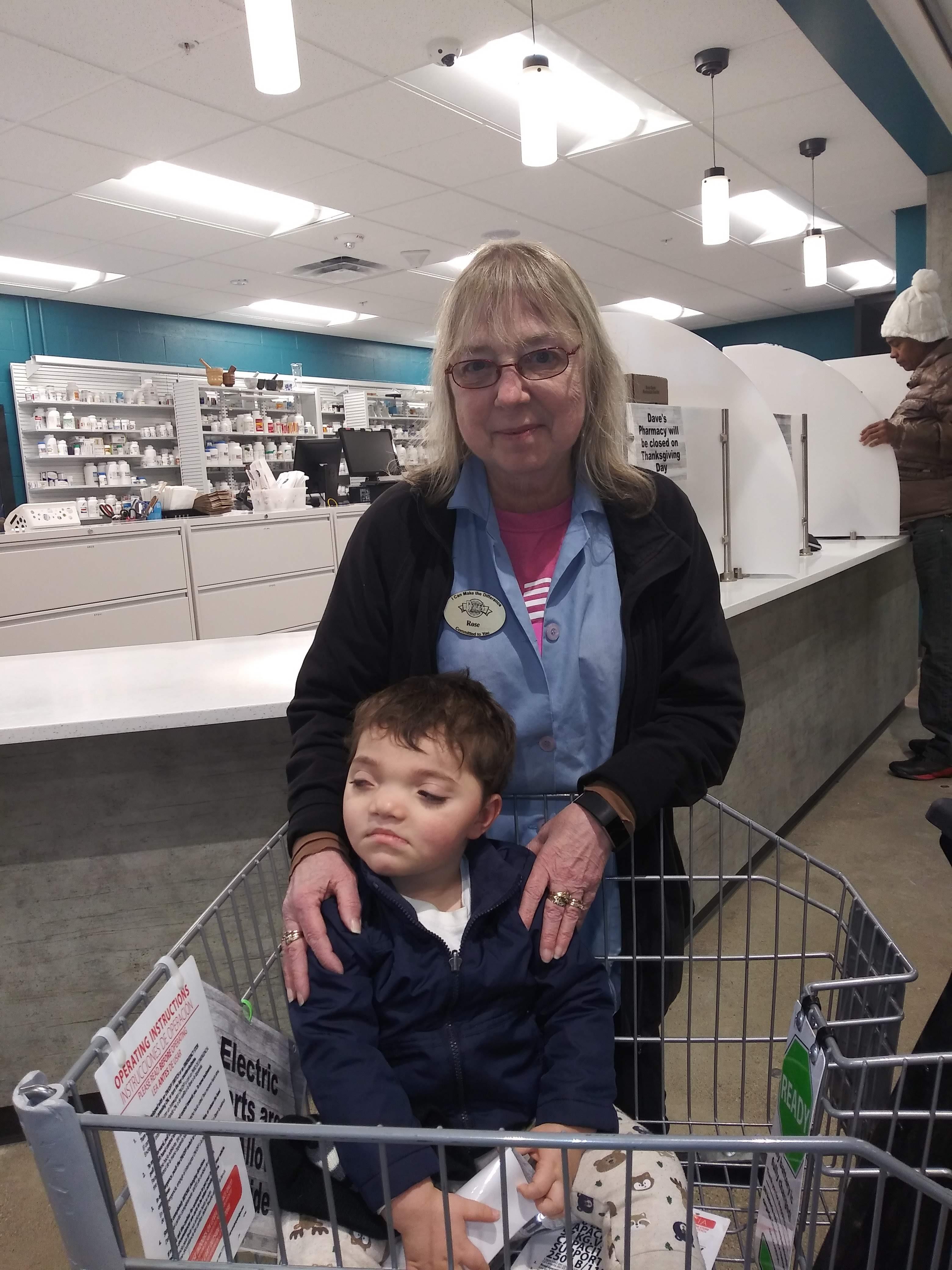 A woman holding a child in a shopping cart