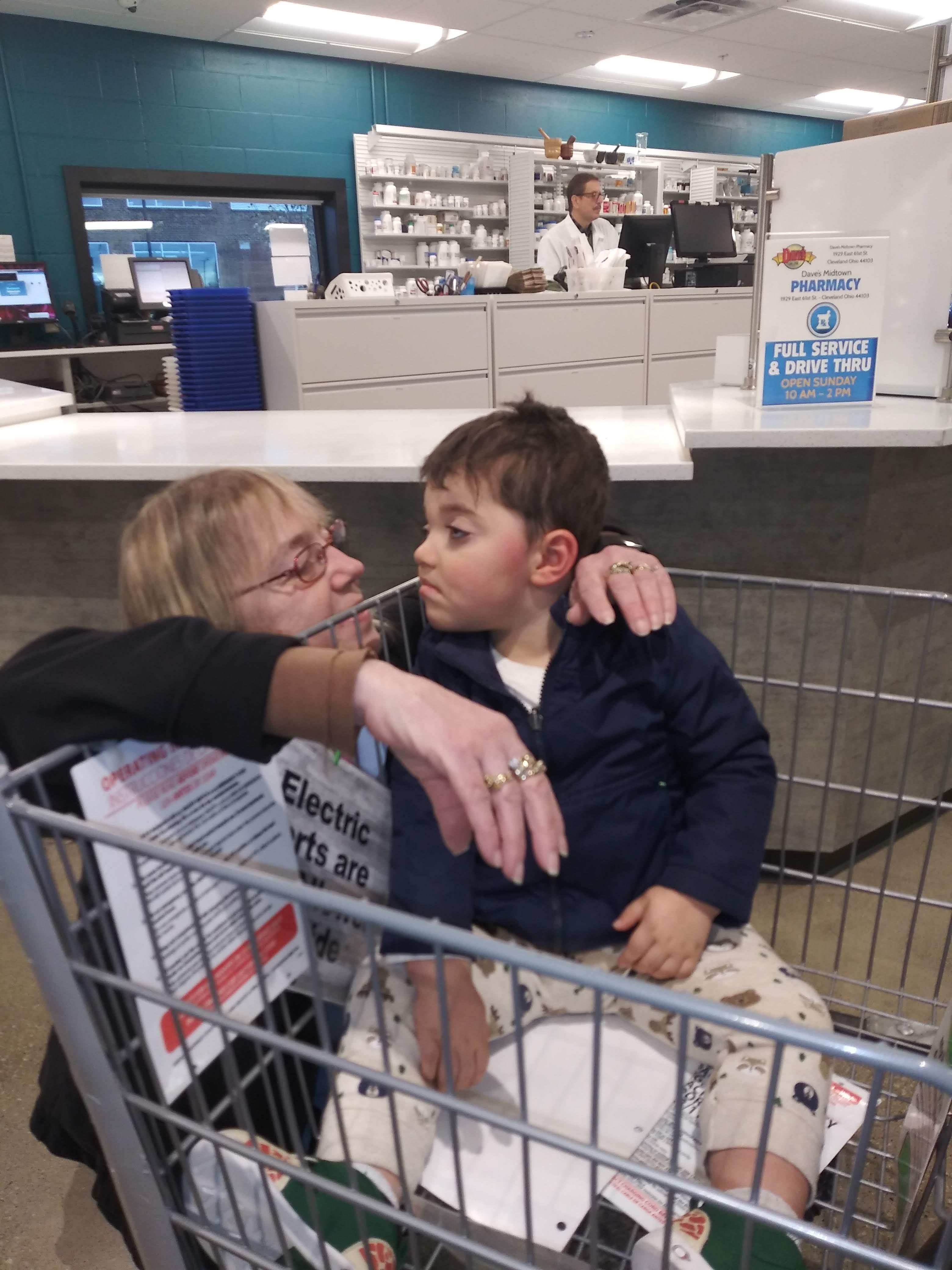 A woman sitting in a shopping cart with a child