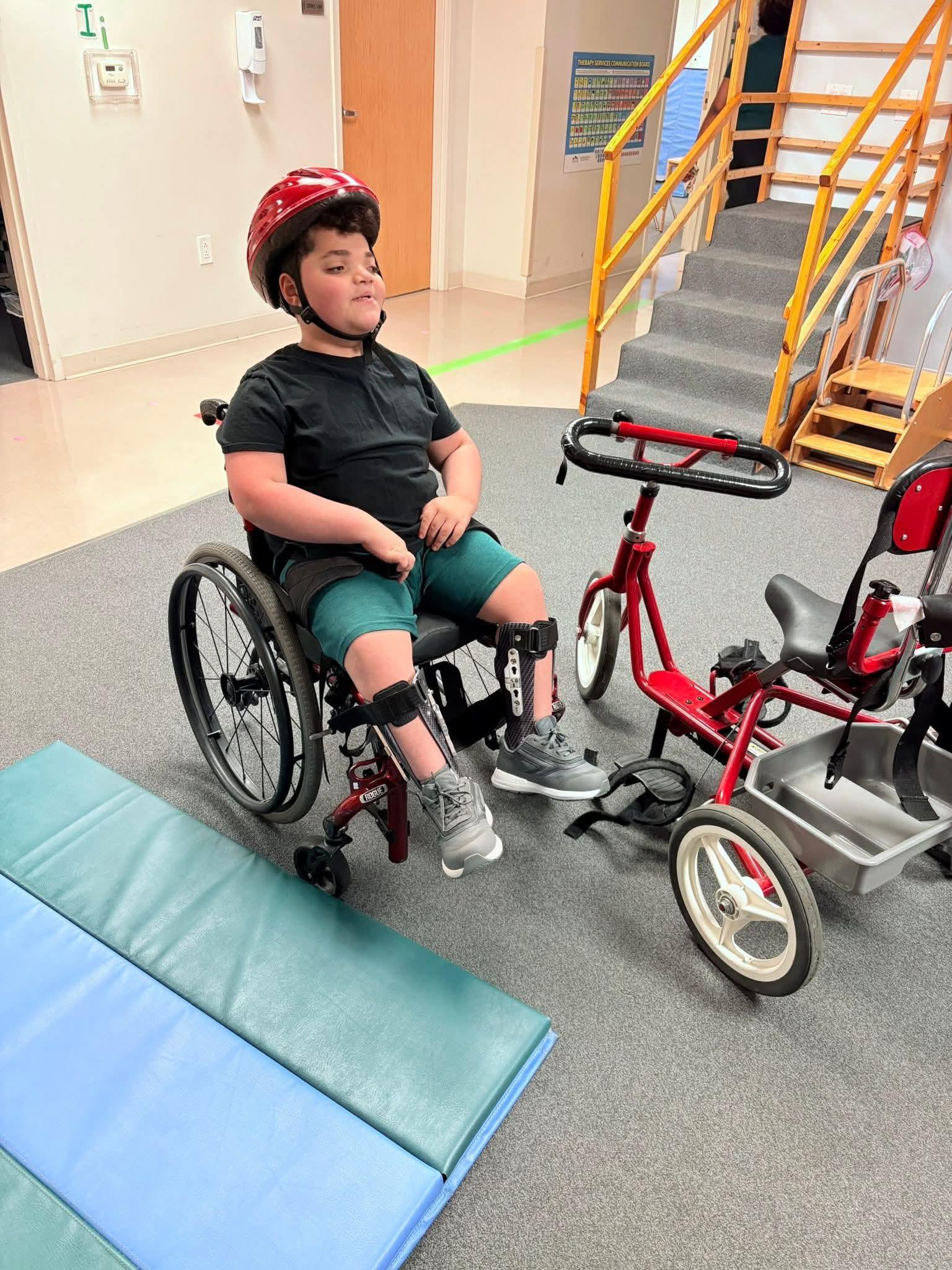 A boy in a wheelchair with a helmet