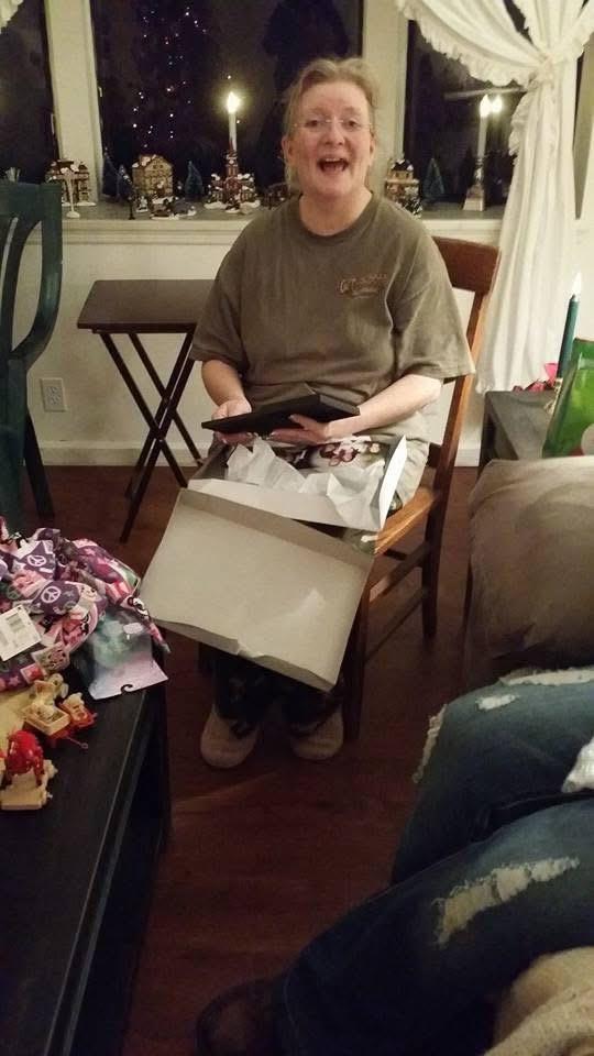 A person sitting in a chair holding a box