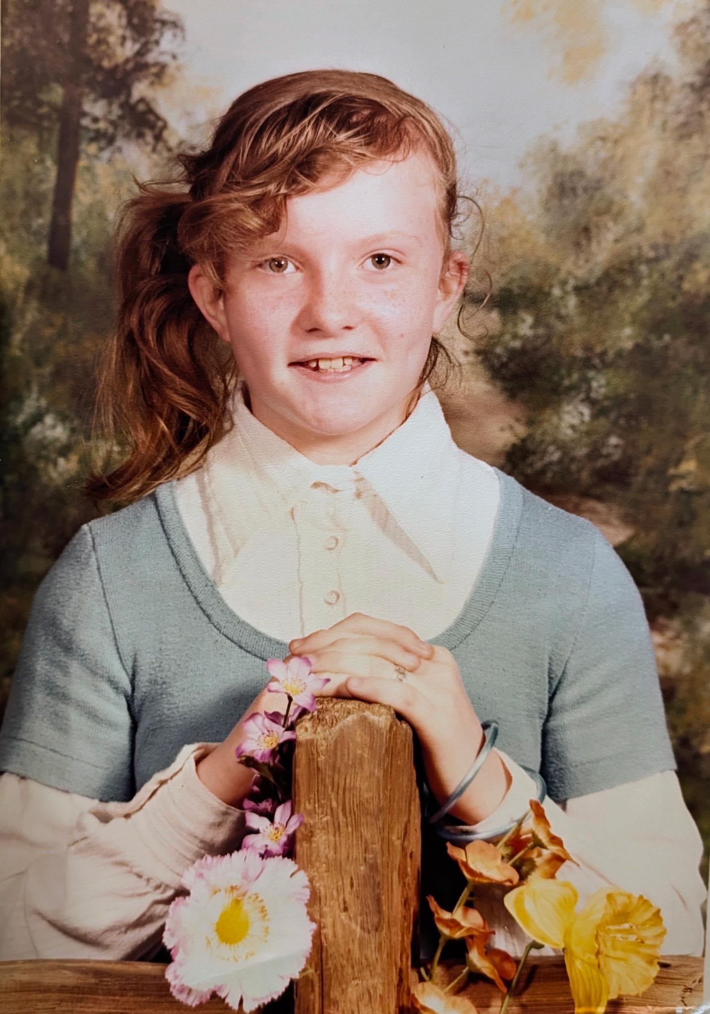 A girl holding a wooden post