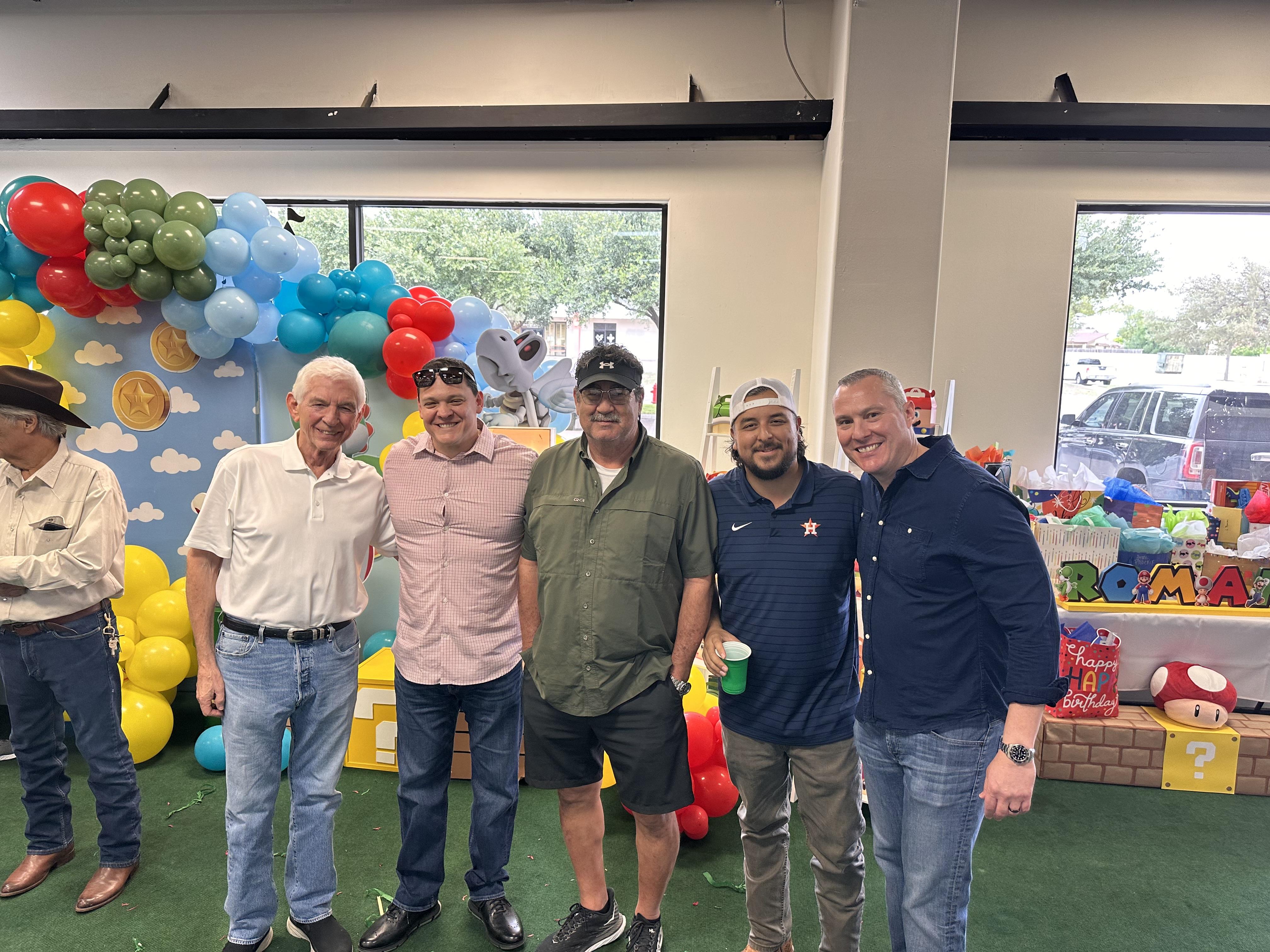 A group of men standing in a room with balloons