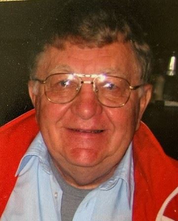A man wearing glasses and a red jacket