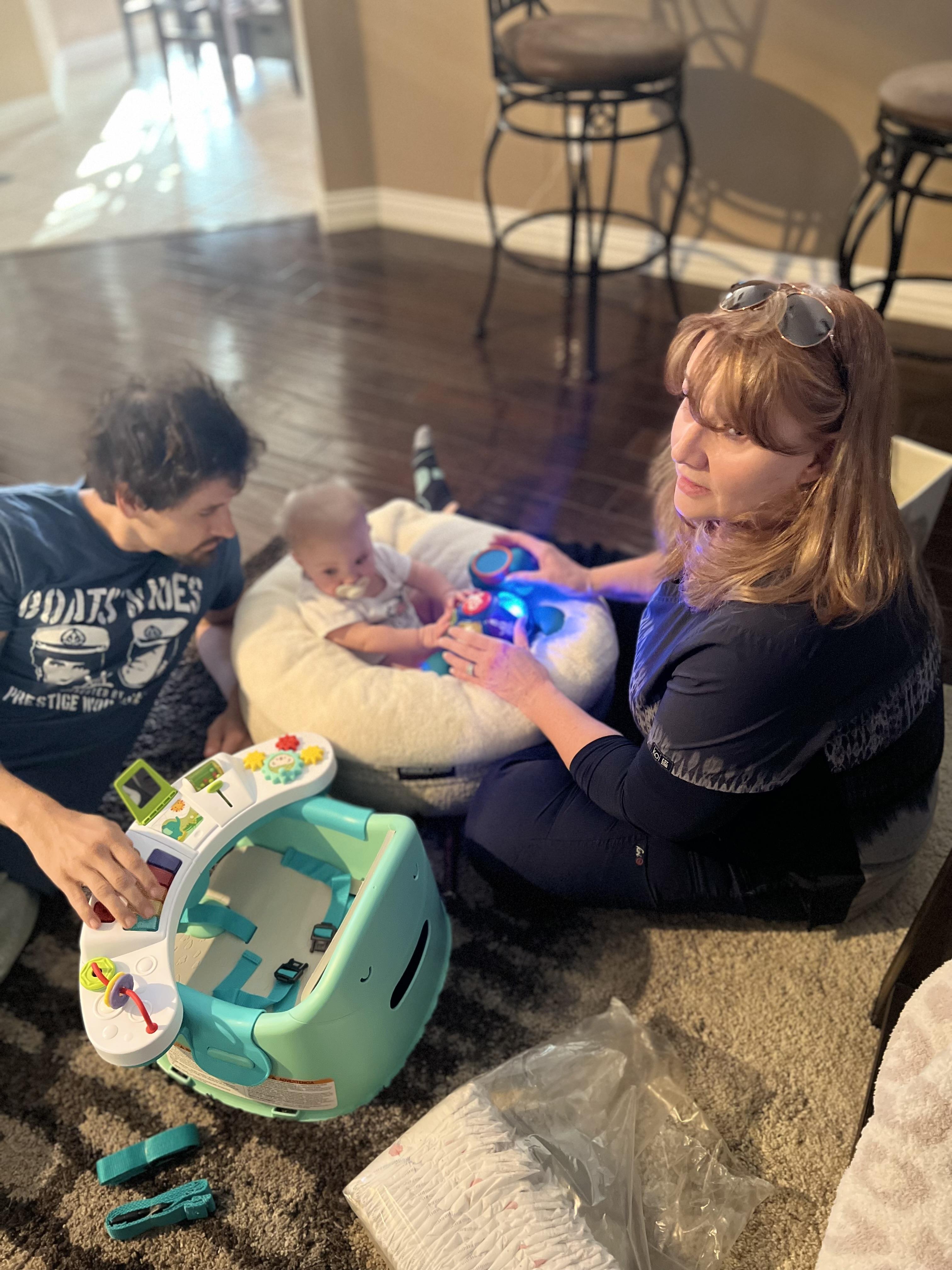 A woman sitting on the floor with a baby