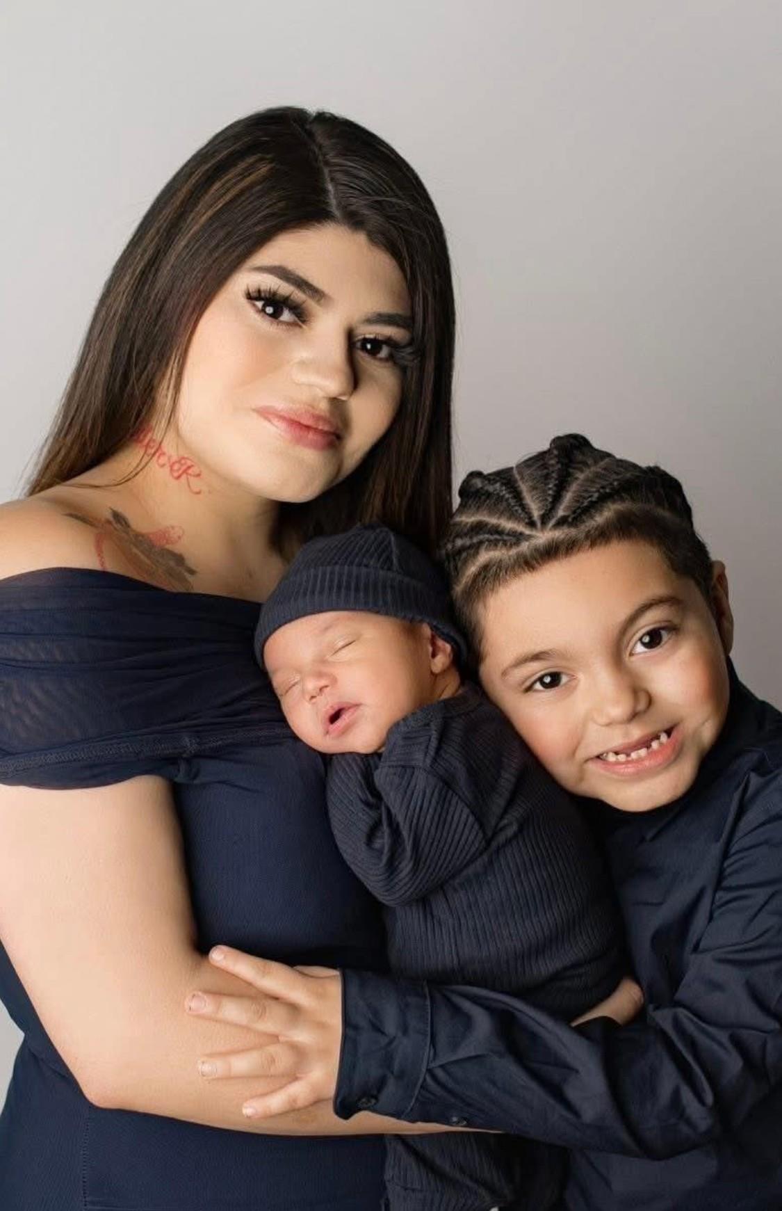 A woman holding a baby and a boy