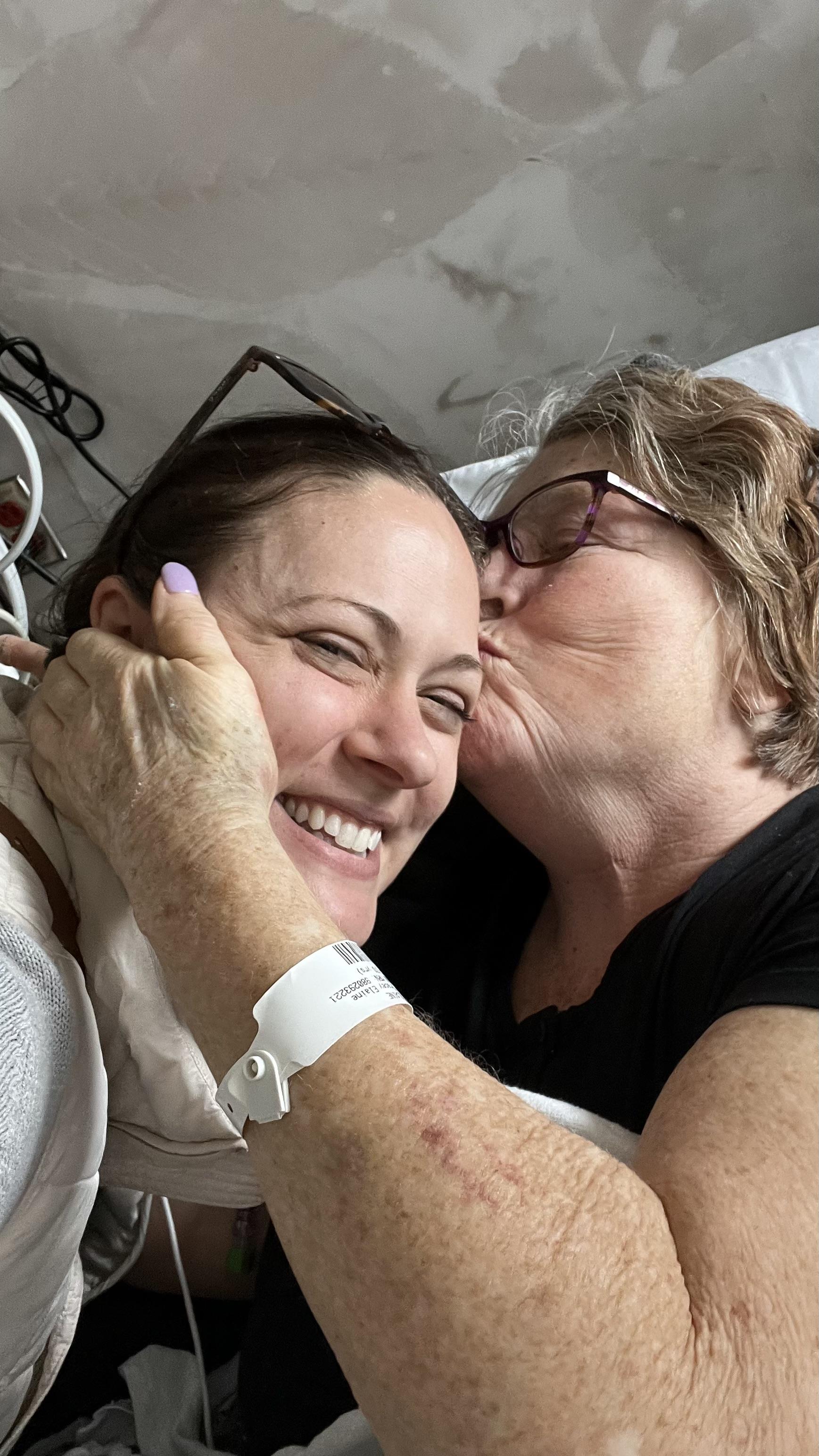 A woman kissing another woman's cheek