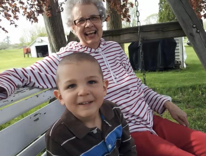 A woman and a boy sitting on a swing
