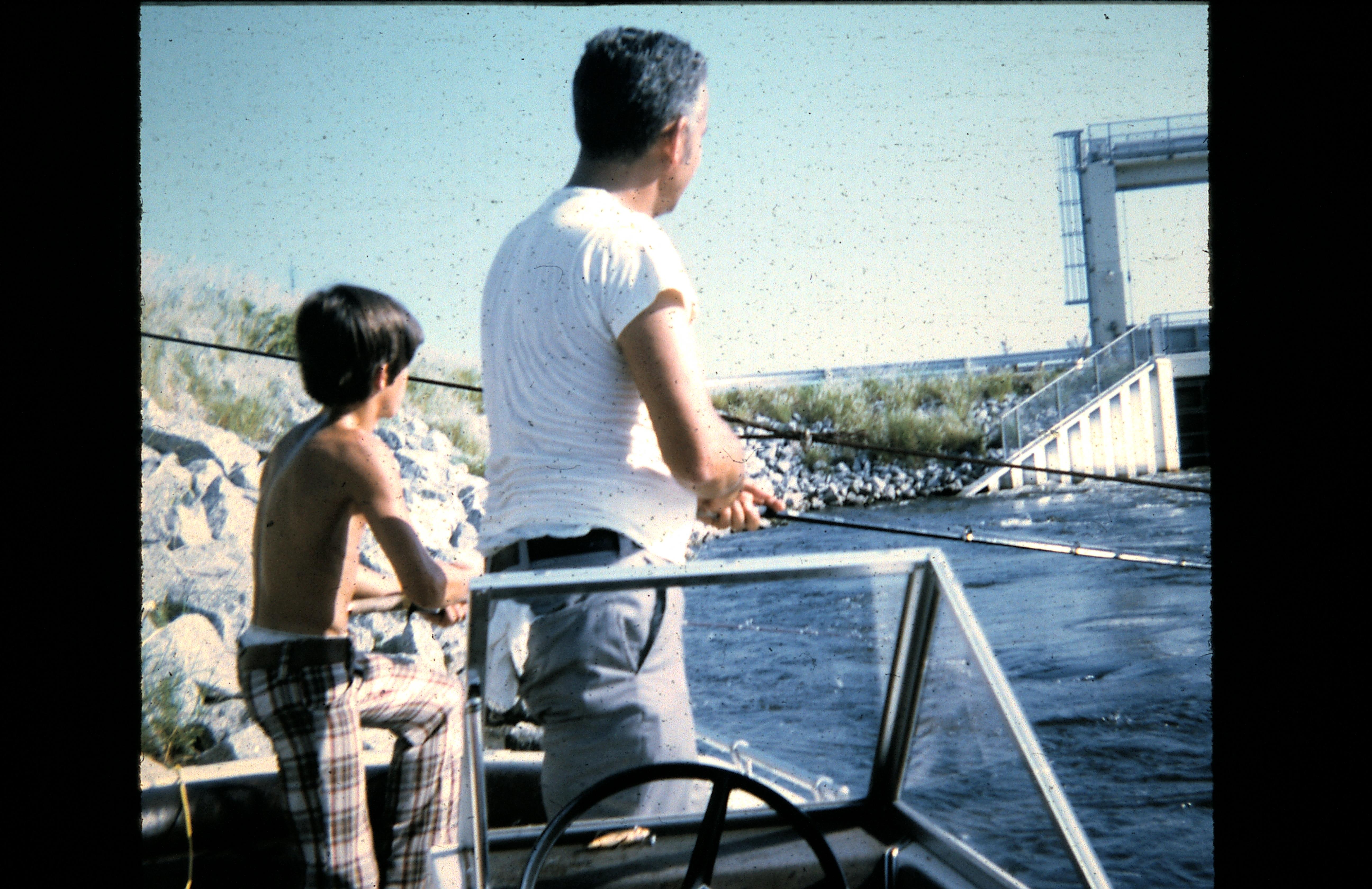 A man and boy fishing on a boat