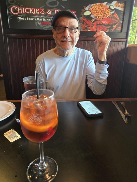 A man sitting at a table with a drink