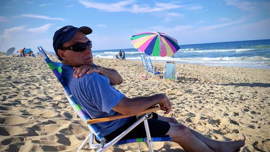 A man sitting in a chair on a beach