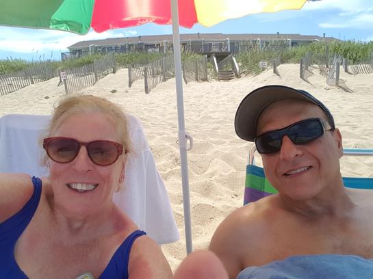A man and woman sitting in chairs at a beach