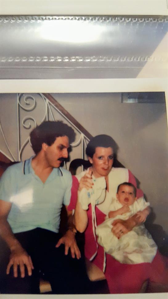 A man and woman holding a baby