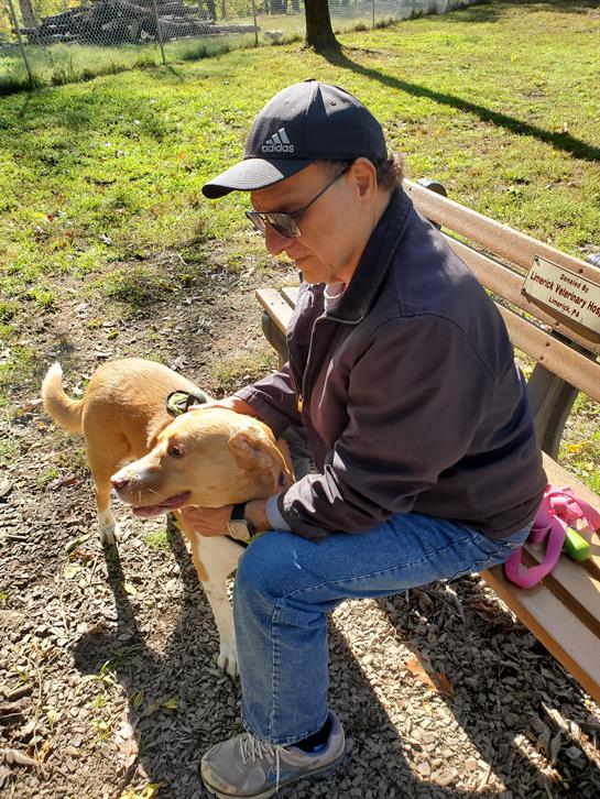 A man sitting on a bench with a dog