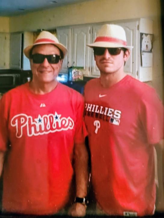 Two men wearing red shirts and hats