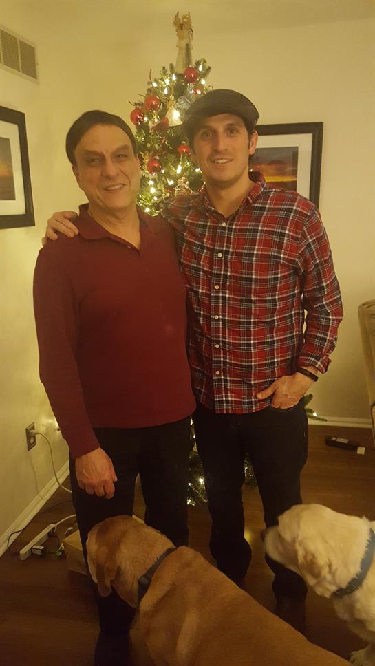 Two men standing next to a christmas tree