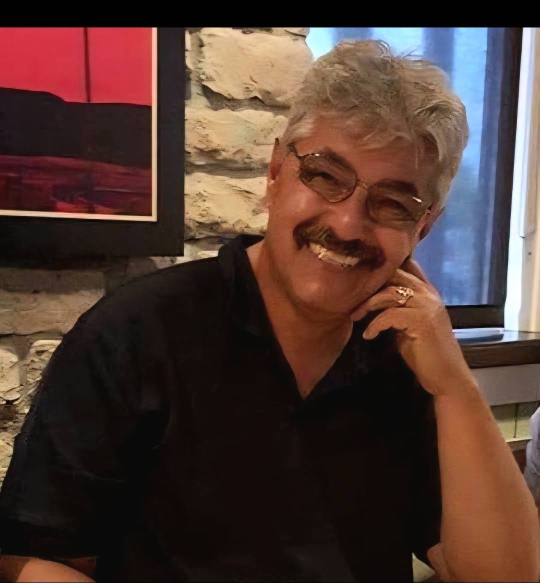 A man with a mustache smiling