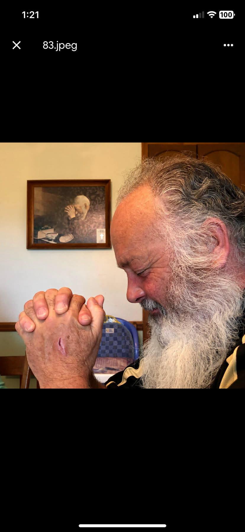 A man with a long beard praying