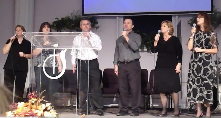 A group of people singing into microphones