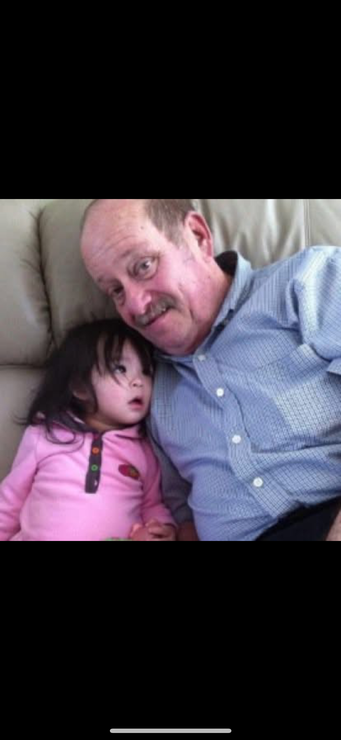 A man and a child lying on a couch