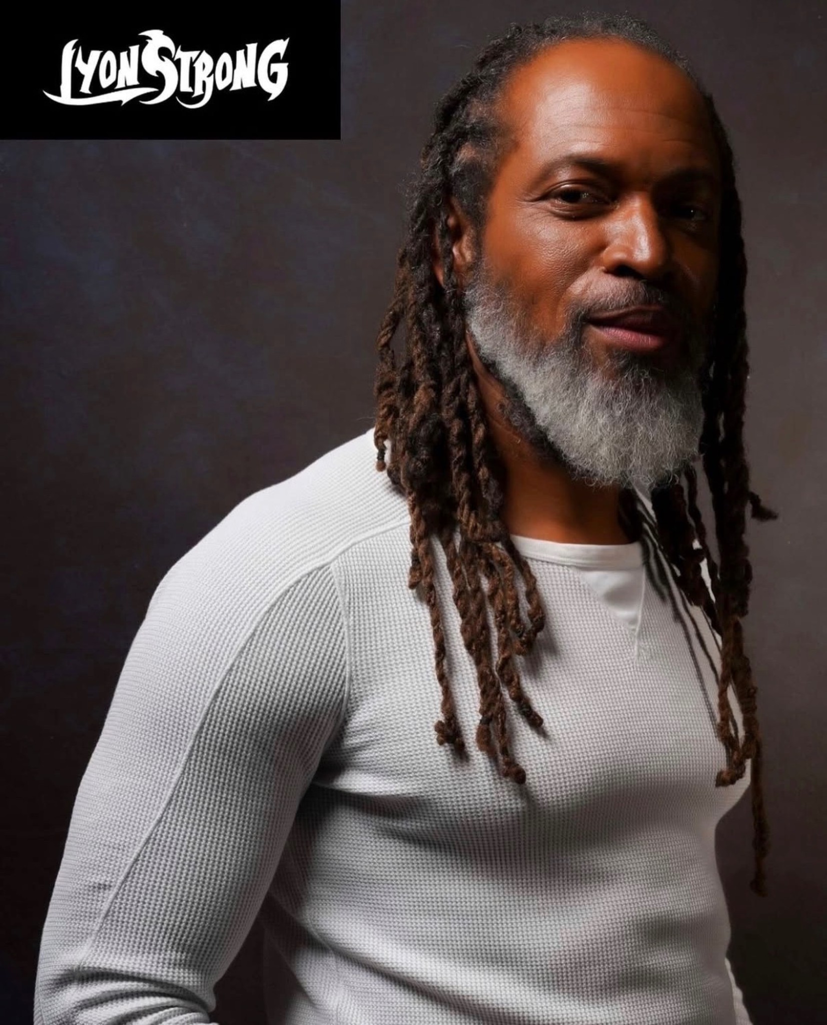 A man with long dreadlocks and a white shirt