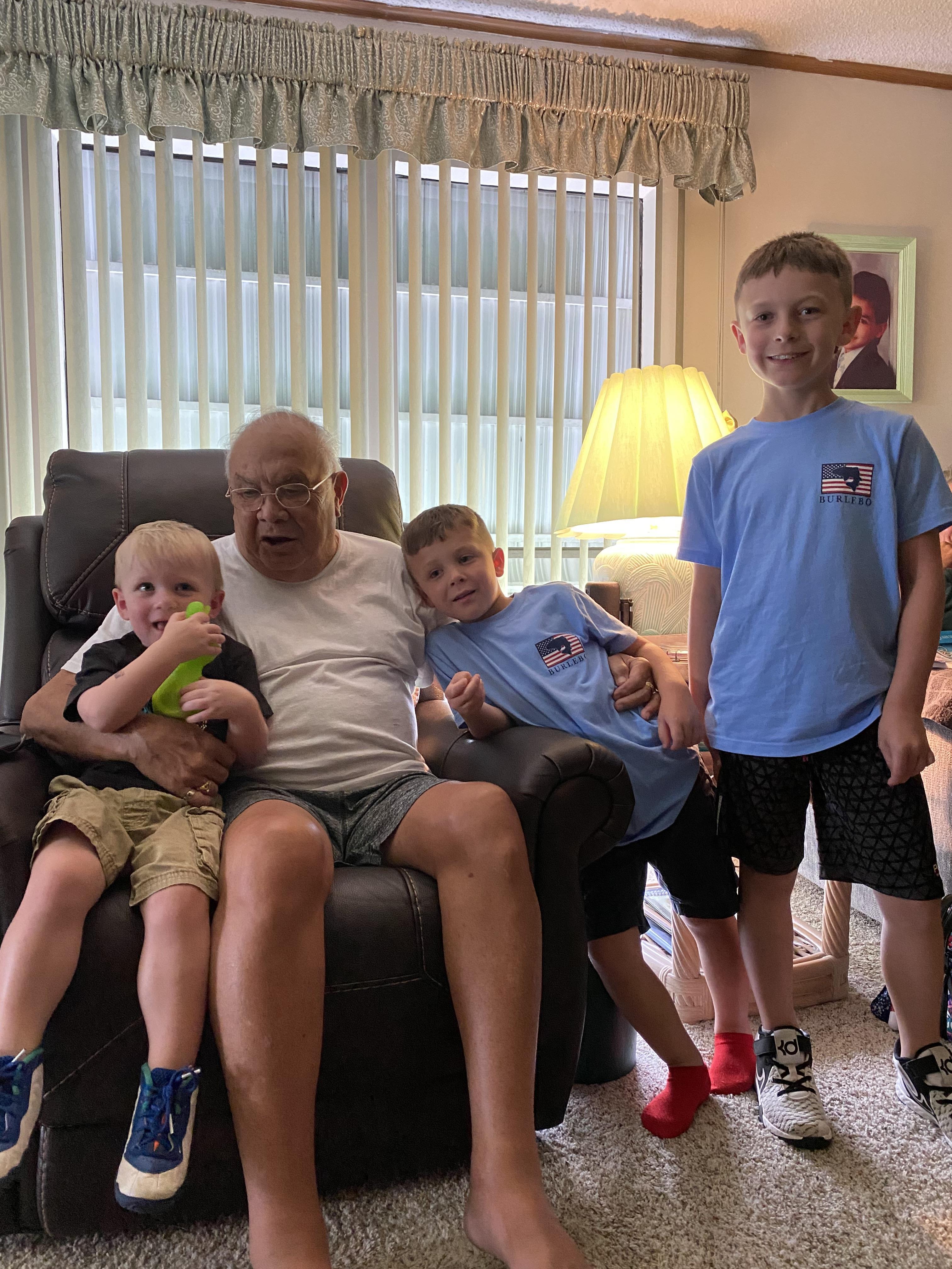 A man sitting on a chair with two boys
