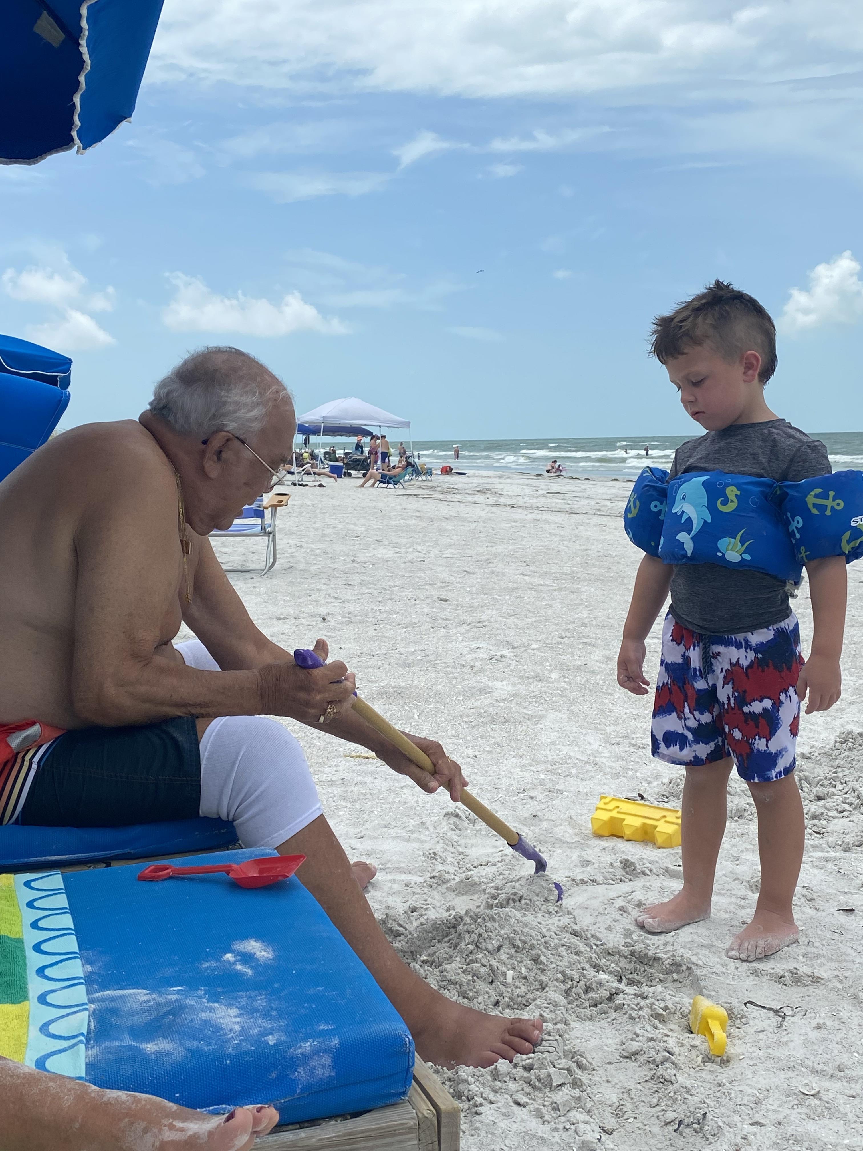 A man and boy playing in the sand