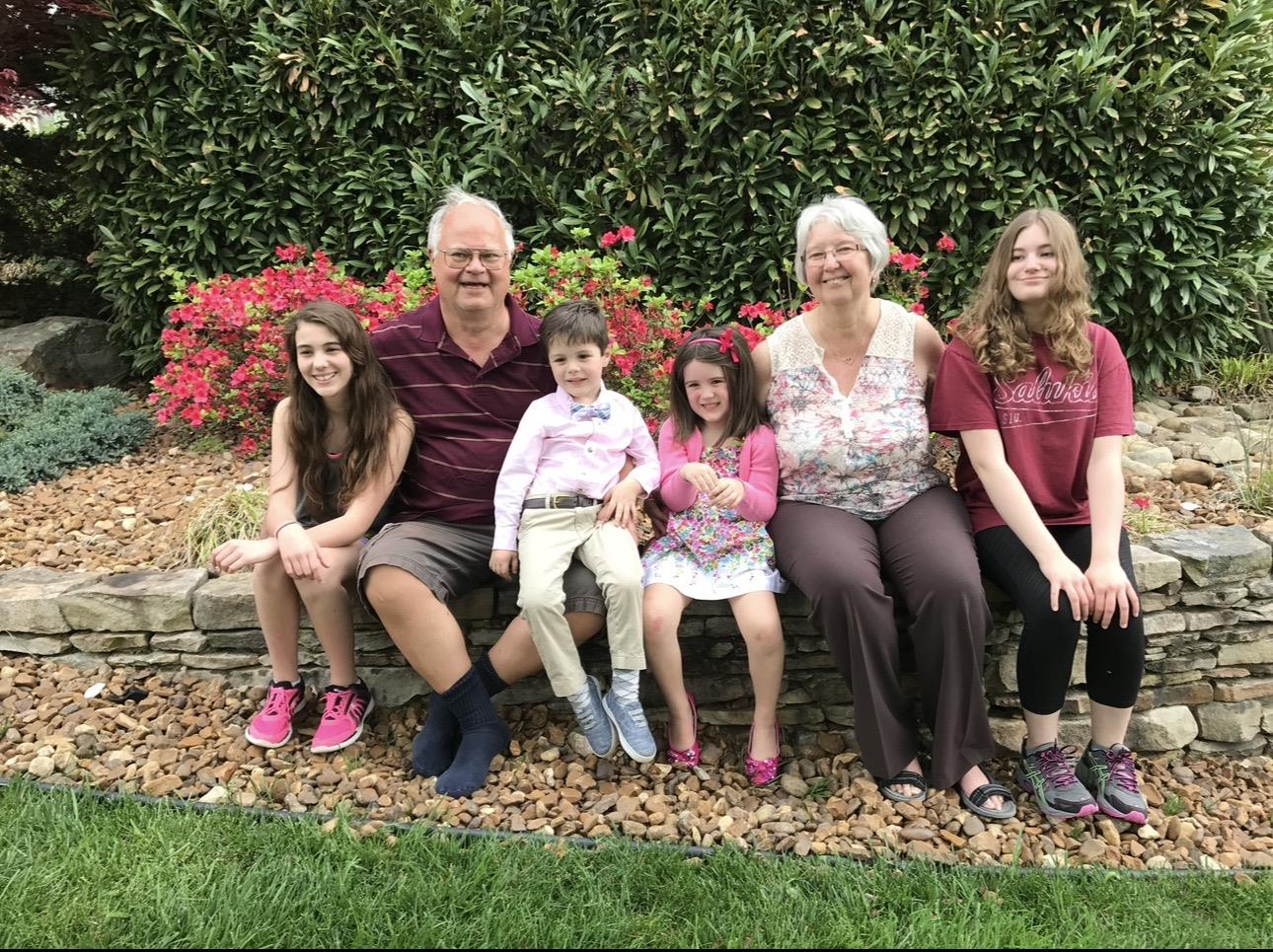 A group of people sitting on a stone bench
