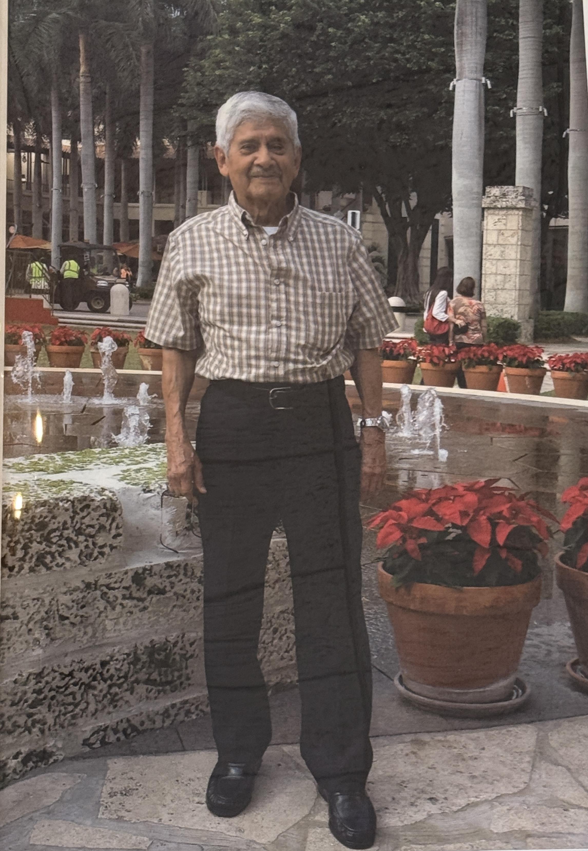An old man standing in front of a fountain