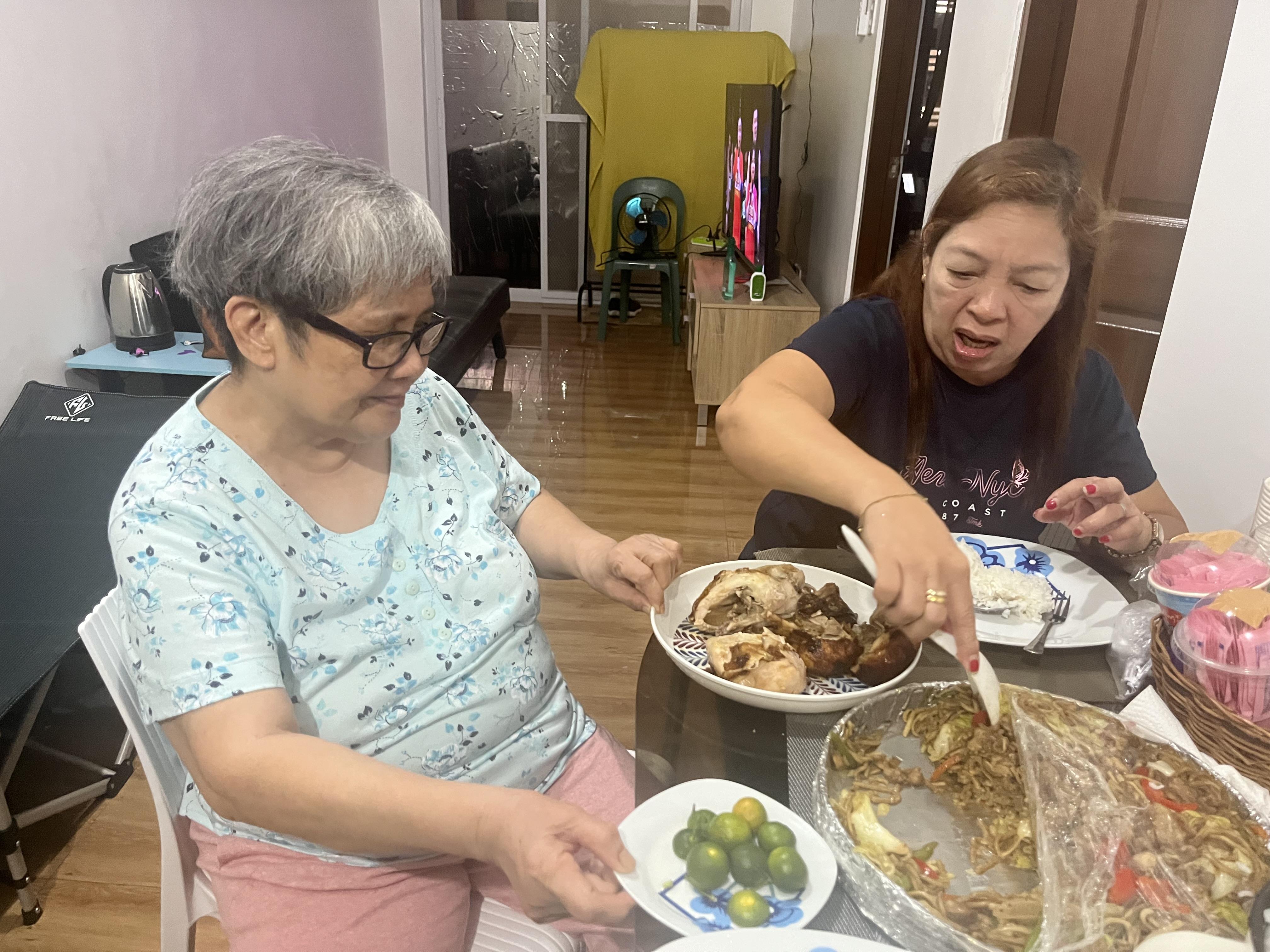 Two women sitting at a table eating food