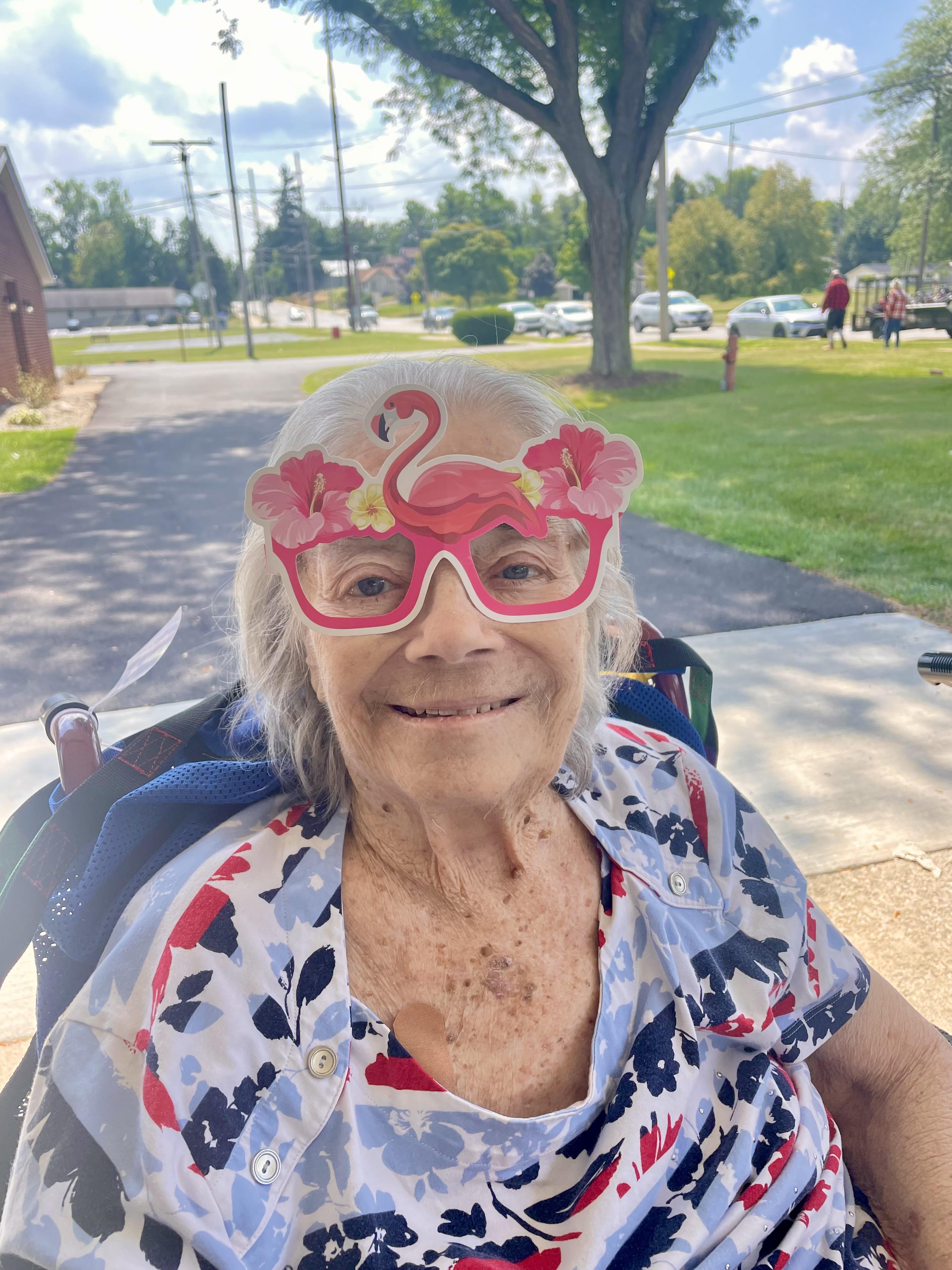 An older woman wearing a flamingo glasses