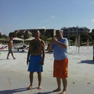 A man taking a selfie with another man on the beach