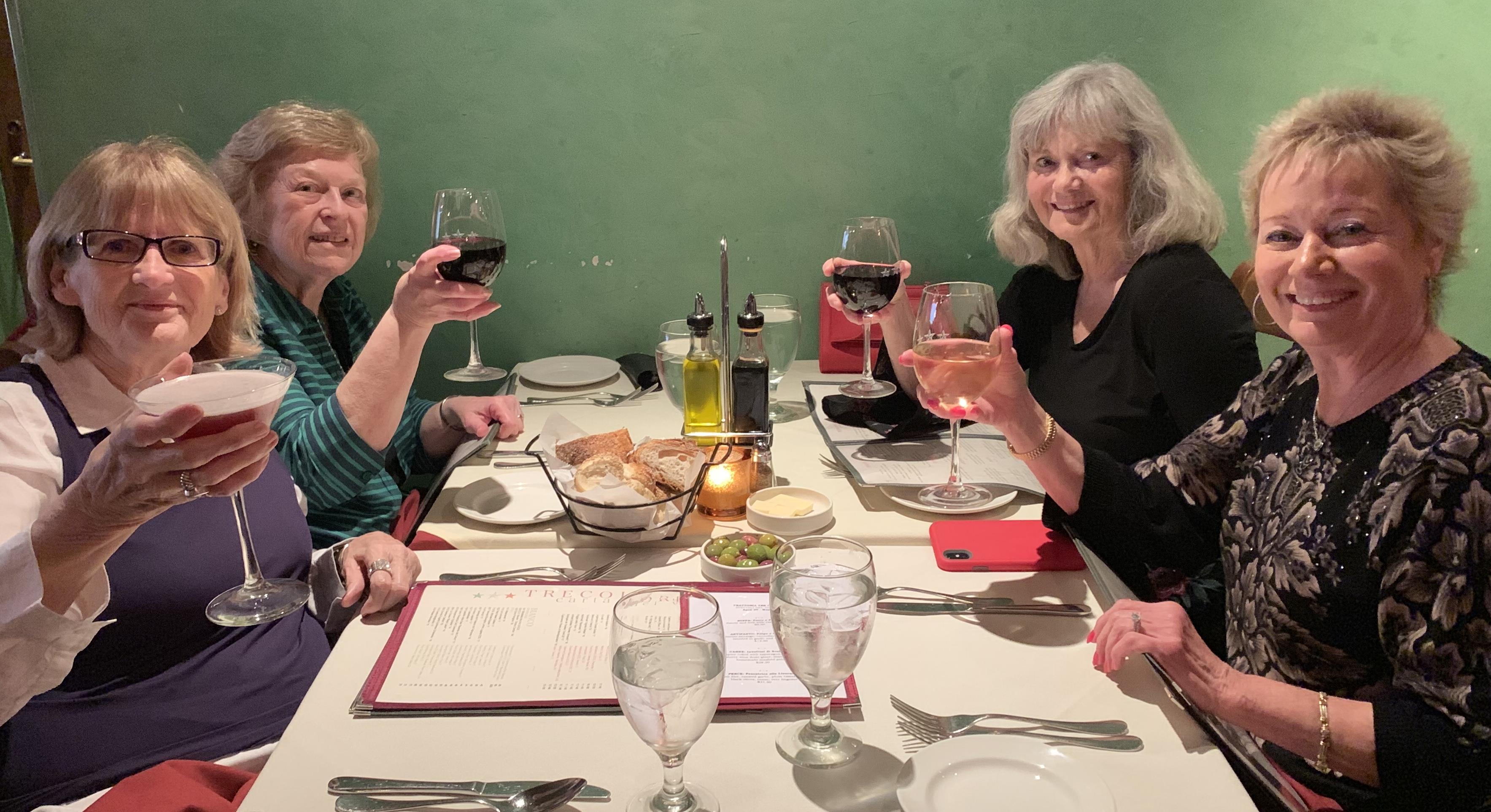 A group of women sitting at a table with wine glasses