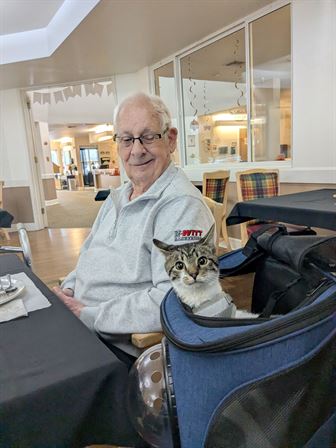 A man sitting in a chair with a cat in his lap