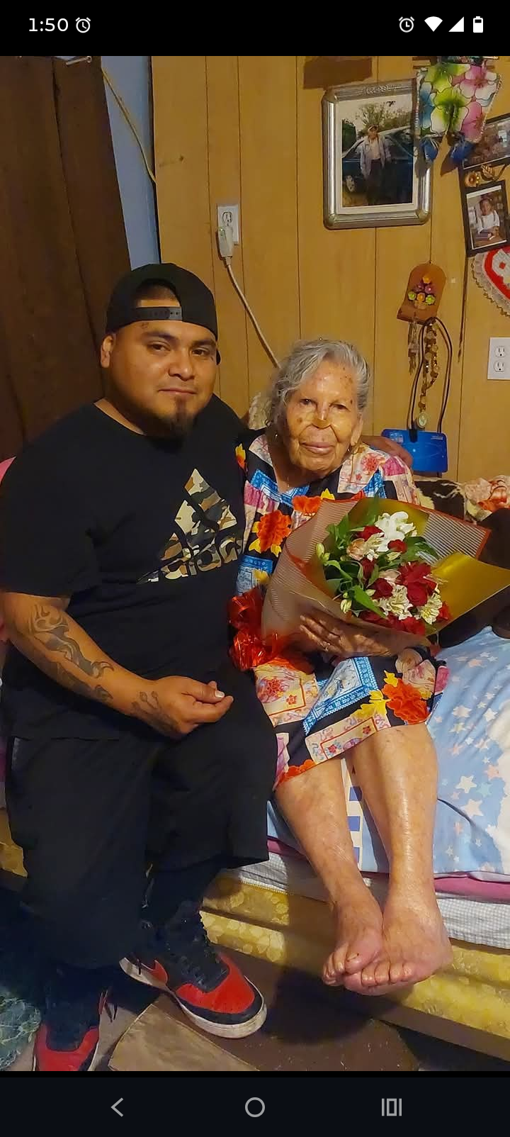 A man and woman sitting on a bed with flowers