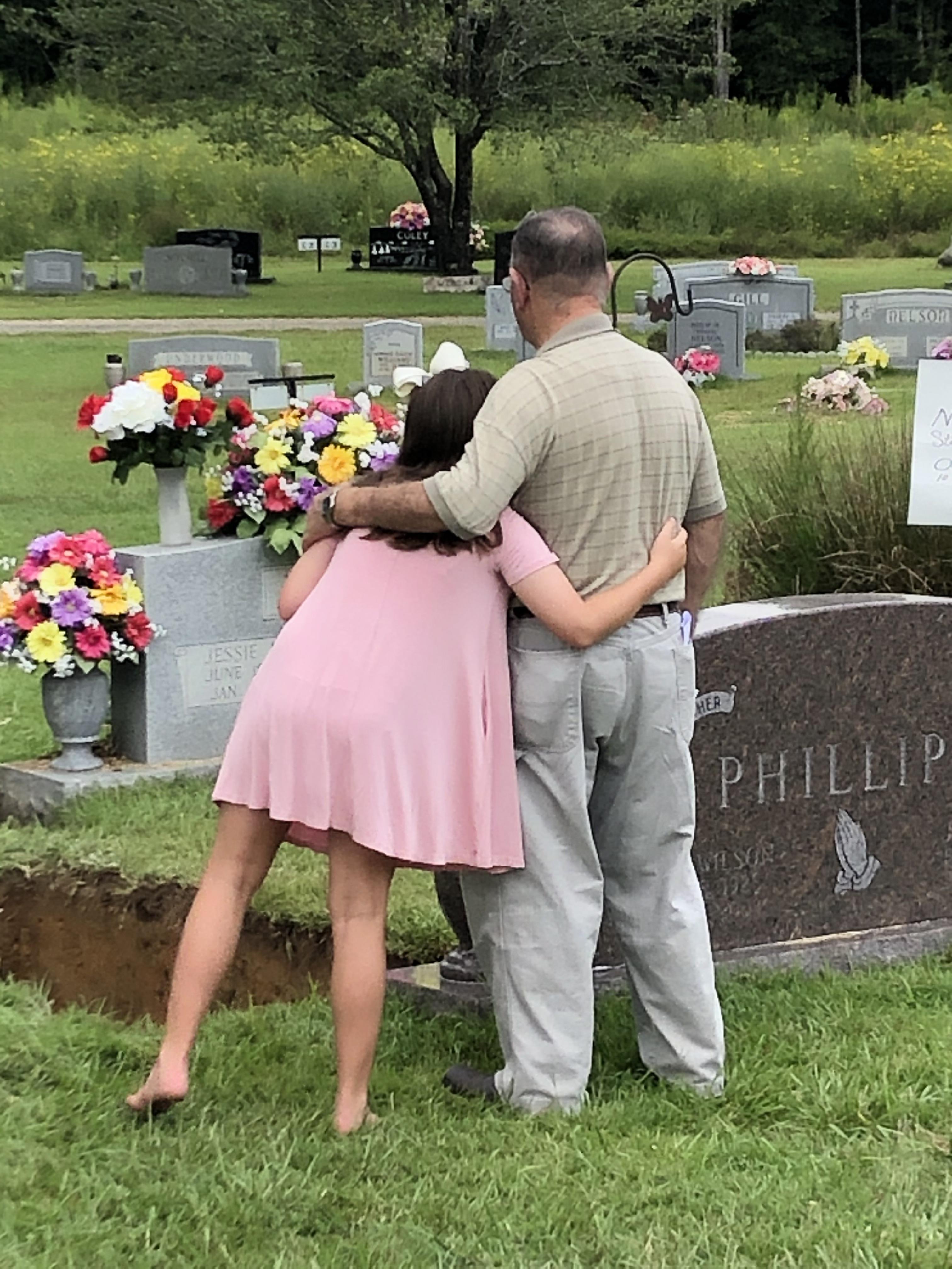 A man and woman hugging in a cemetery