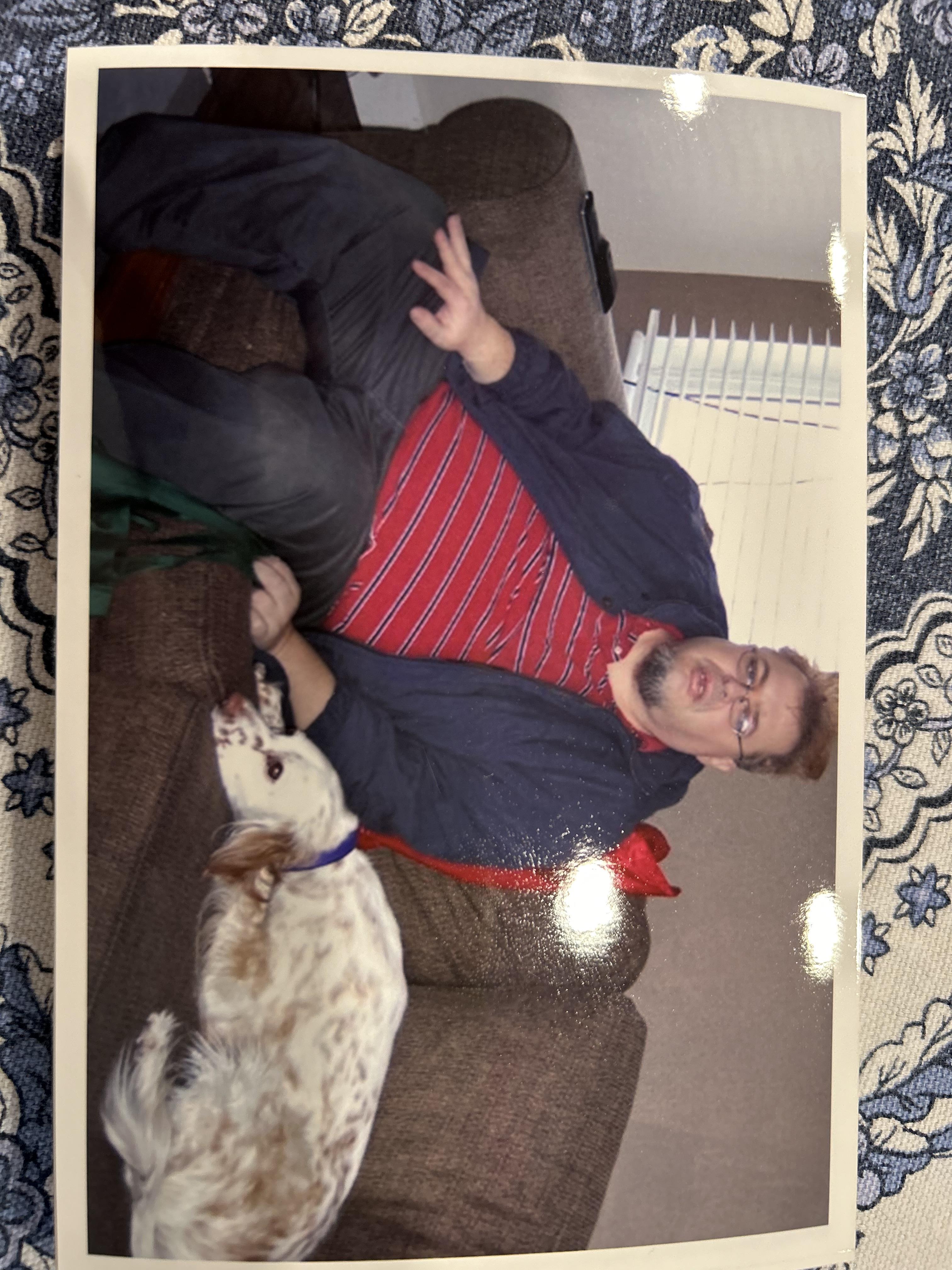A man sitting on a couch with a dog