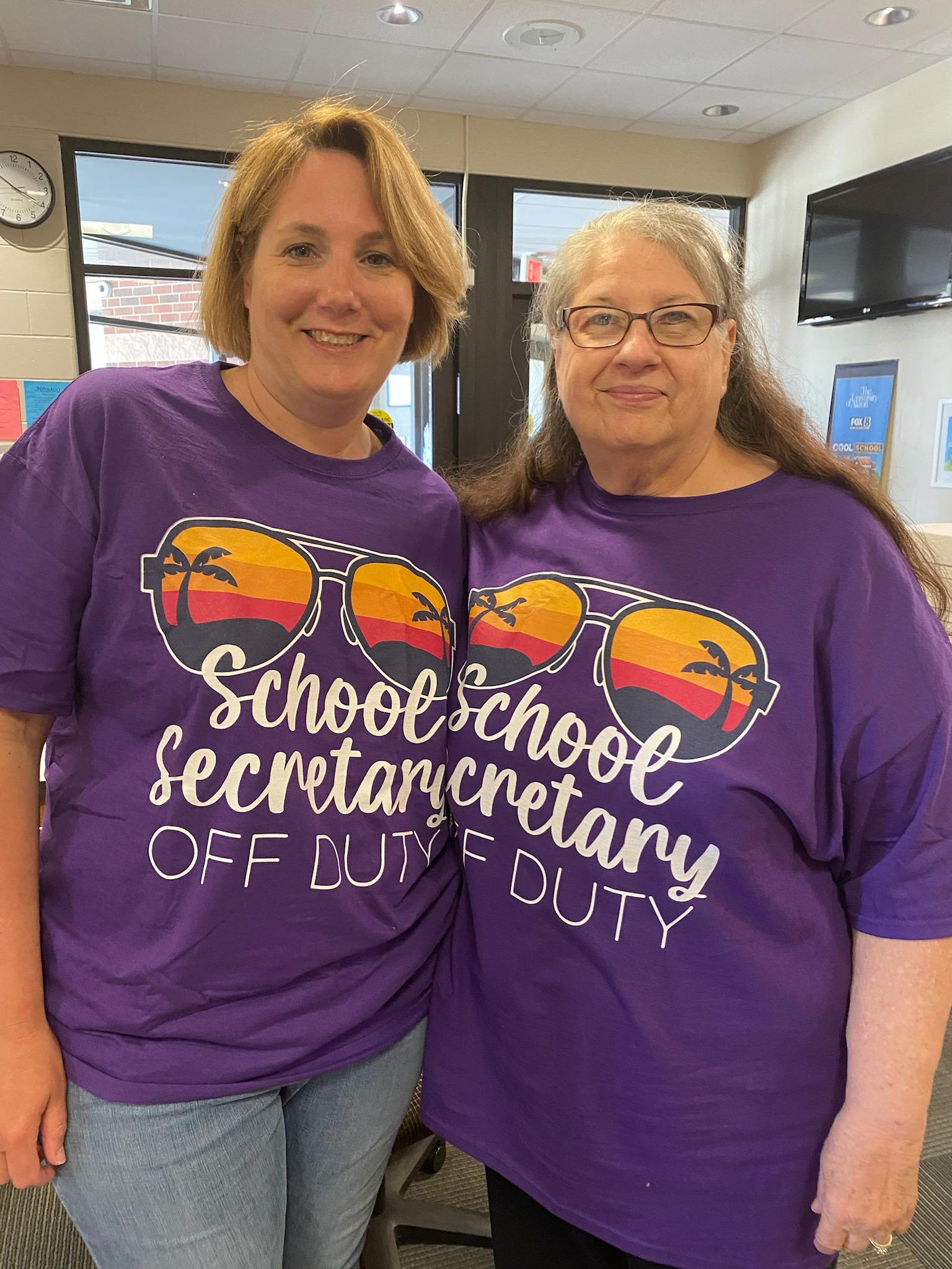 Two women wearing purple shirts