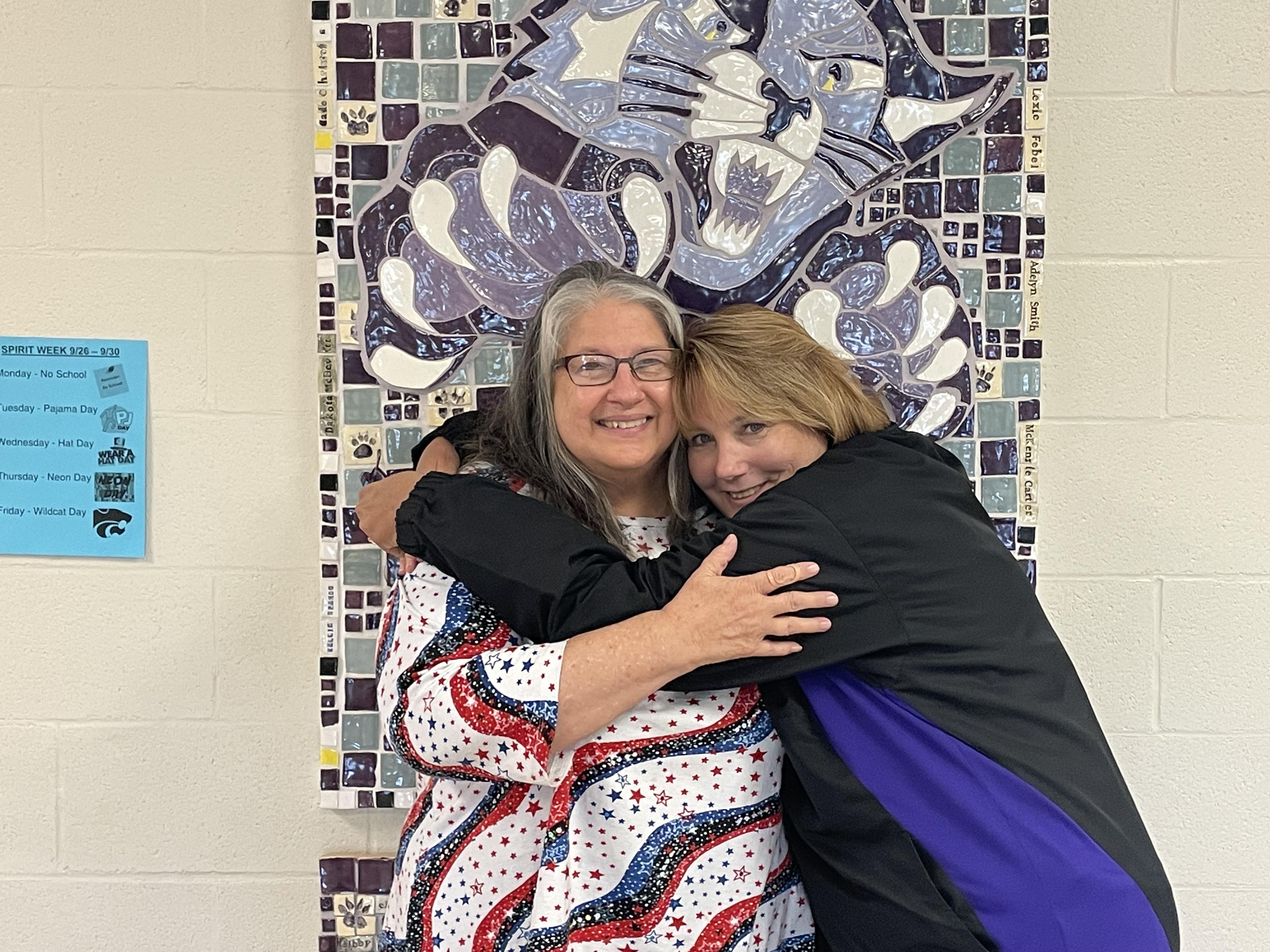 Two women hugging each other