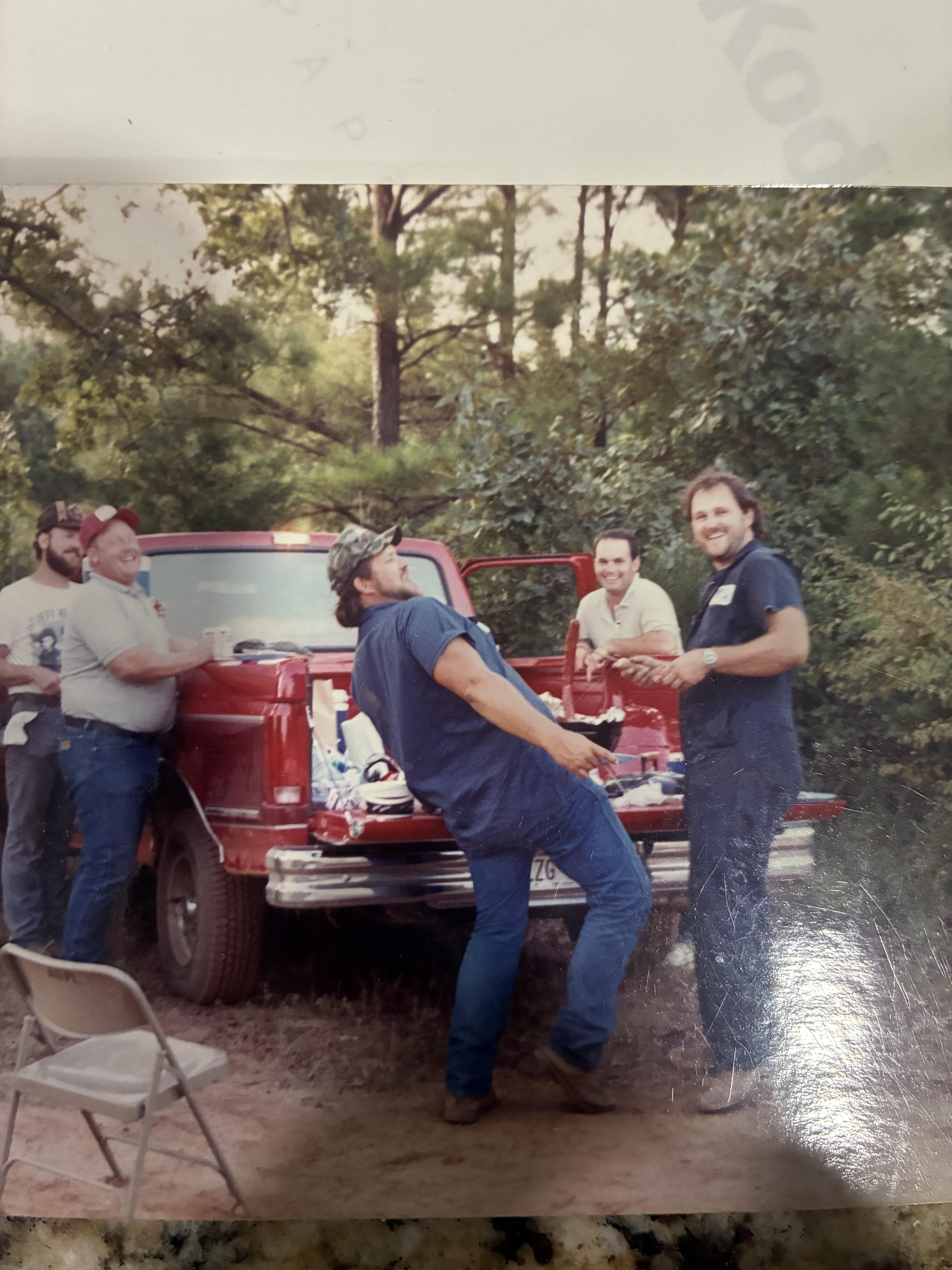 A group of men standing around a red truck
