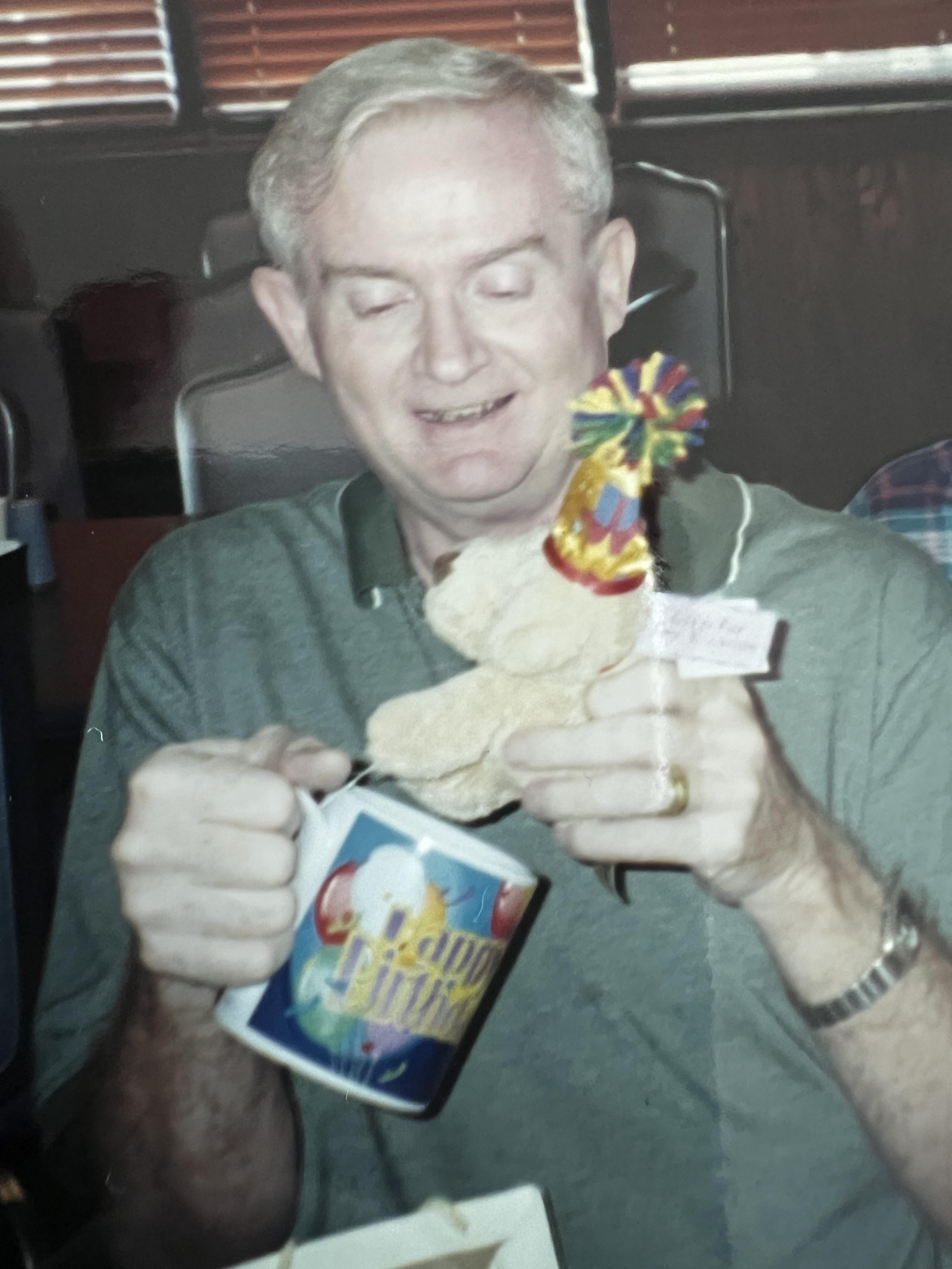 A man holding a stuffed animal and a mug