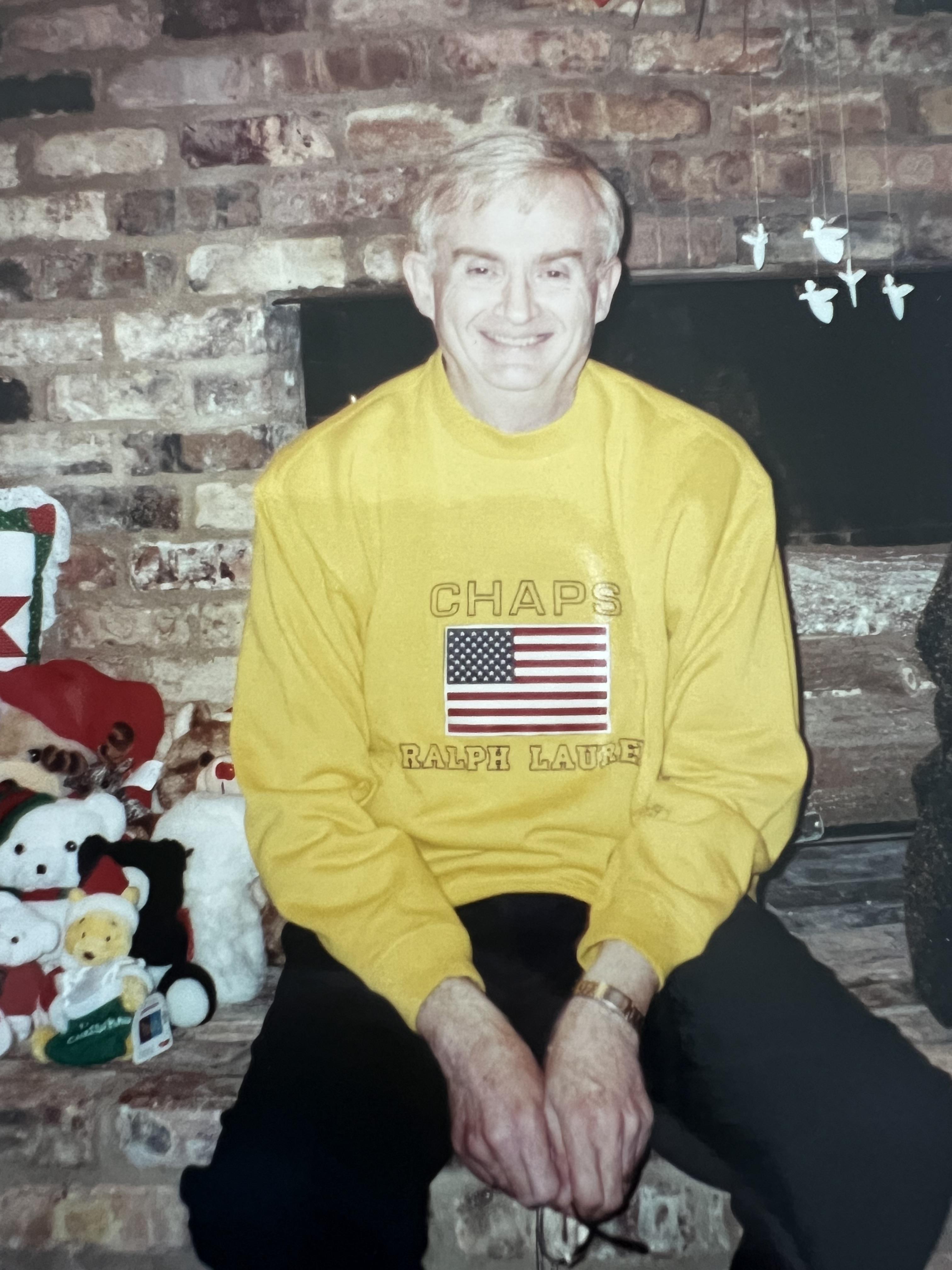 A man sitting in front of a fireplace