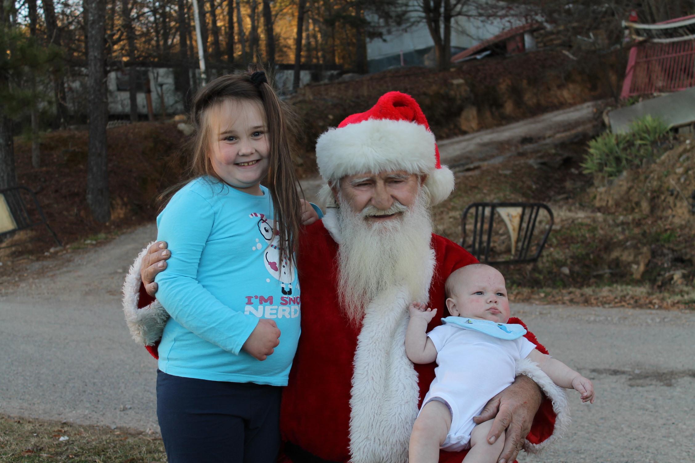A man in a santa garment with two children