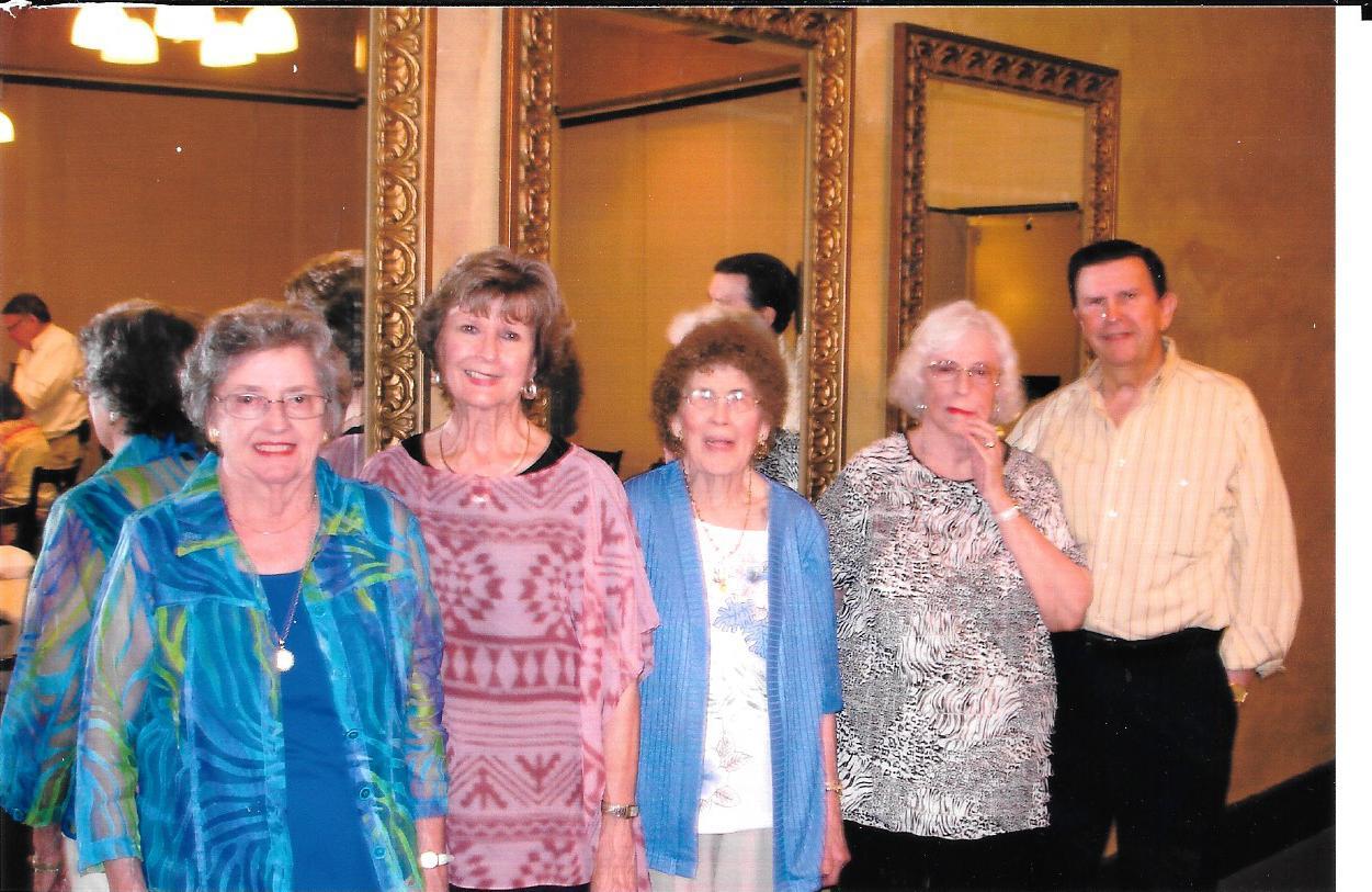 A group of older people standing in front of a mirror