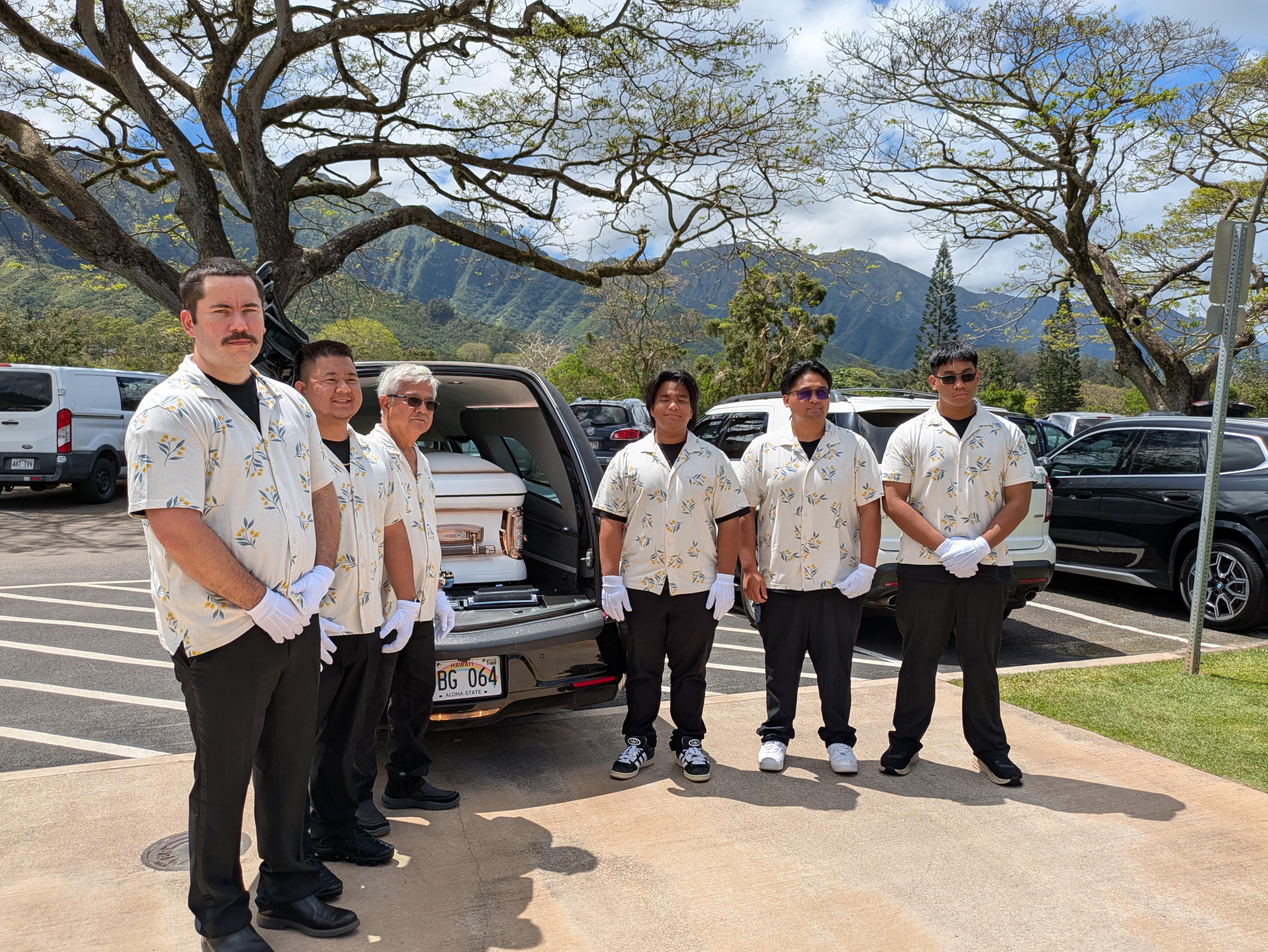 A group of people standing in front of a car